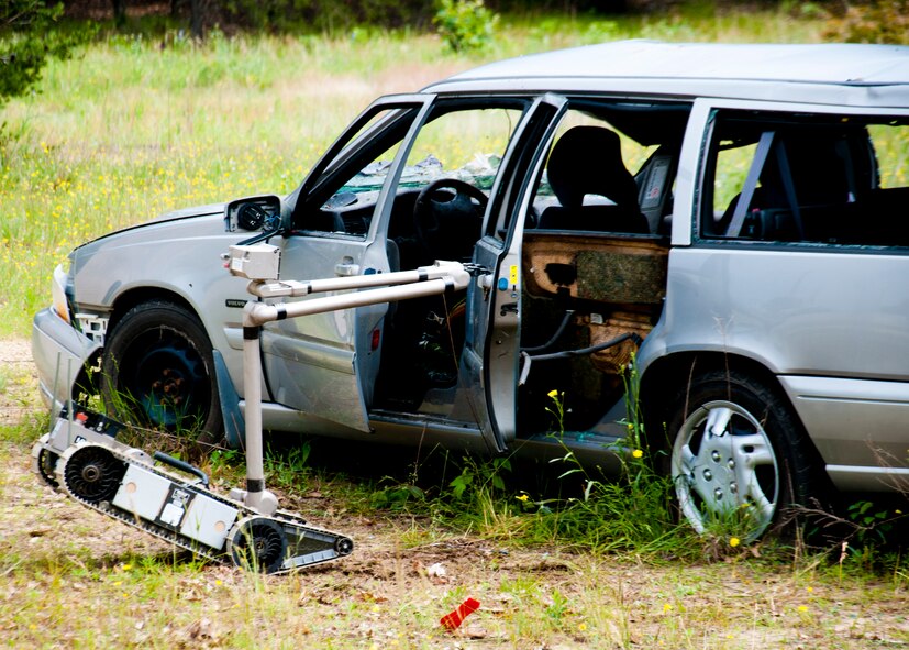 A robot controlled by U.S. Air Force explosive ordnance disposal technicians opens a car door to safely gain access to a simulated improvised explosive device during the Patriot Warrior exercise at Fort McCoy, Wis., June 21, 2015. Patriot Warrior is a joint exercise designed to demonstrate contingency deployment training ranging from bare base buildup to full operational capabilities. It supports Exercise Global Lightning, a Combat Support Training Exercise (CSTX) including Global Medic 15 and Quartermaster Liquid Logistics Exercise 15 (QLLEX). Over 6,000 members from U.S. service components including Air Force, Army, and Navy (Active, Guard, and Reserve) participated alongside British and Canadian forces. (U.S. Air Force photo by Senior Airman Daniel Liddicoet/Released)