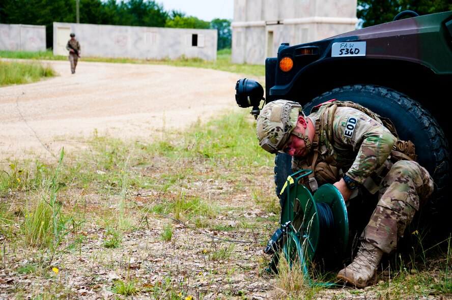 MSgt. Shawn Lundgren, 446th Civil Engineer Squadron explosive ordnance disposal technician, unravels detonation cord to neutralize a simulated improvised explosive device during the Patriot Warrior exercise at Fort McCoy, Wis., June 21, 2015. Patriot Warrior is a joint exercise designed to demonstrate contingency deployment training ranging from bare base buildup to full operational capabilities. It supports Exercise Global Lightning, a Combat Support Training Exercise (CSTX) including Global Medic 15 and Quartermaster Liquid Logistics Exercise 15 (QLLEX). Over 6,000 members from U.S. service components including Air Force, Army, and Navy (Active, Guard, and Reserve) participated alongside British and Canadian forces. (U.S. Air Force photo by Senior Airman Daniel Liddicoet/Released)