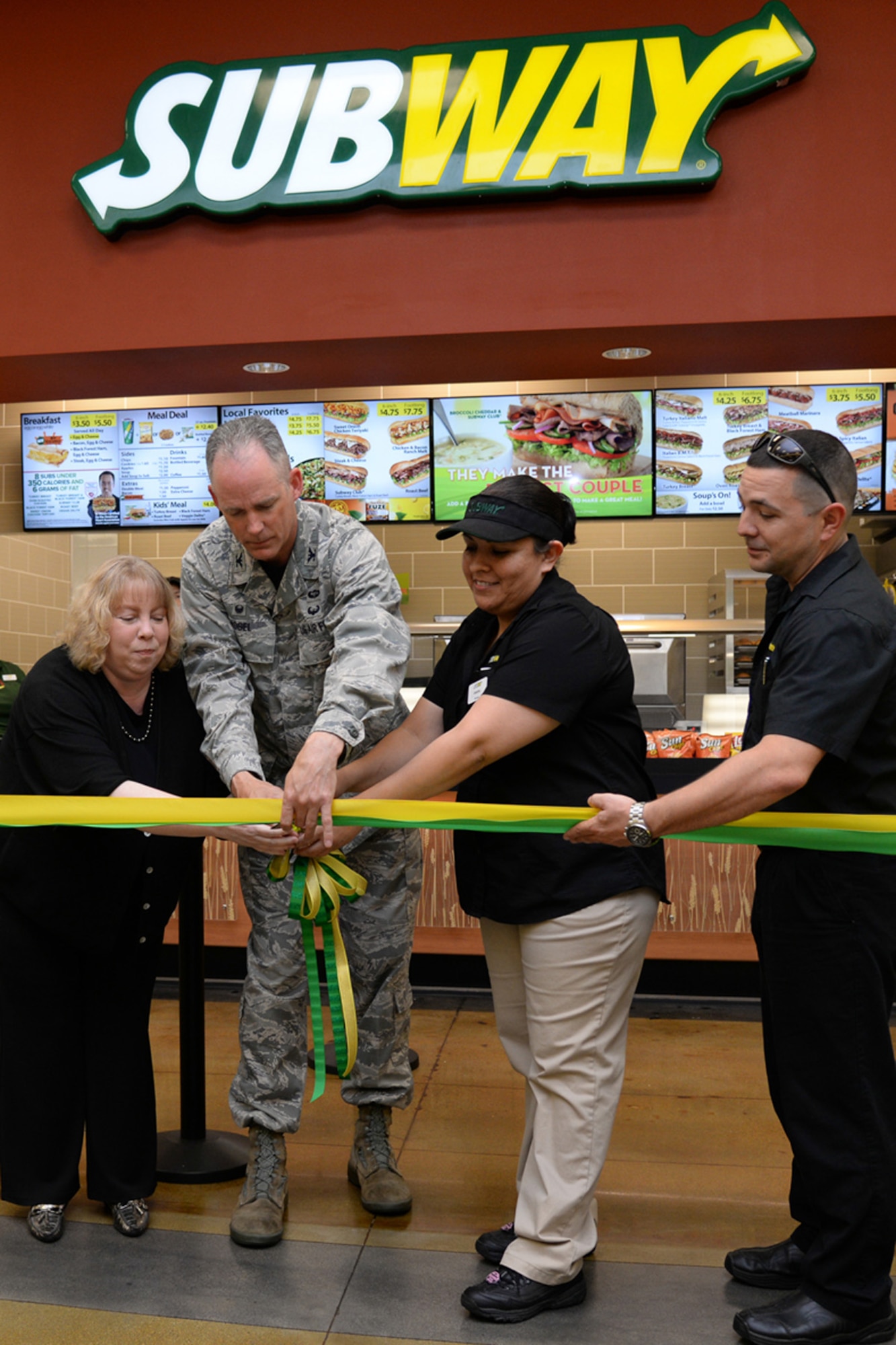 Col. Michael A. Vogel, installation commander, along with Kathi Zeller (right), Army Air Force Exchange Service general manager, Sandra Solis, Hanscom Subway manager and Korey Martinez, Subway manager, cut the ribbon on the Subway restaurant in the AAFES mall June 19. (U.S. Air Force photo by Linda LaBonte Britt)
