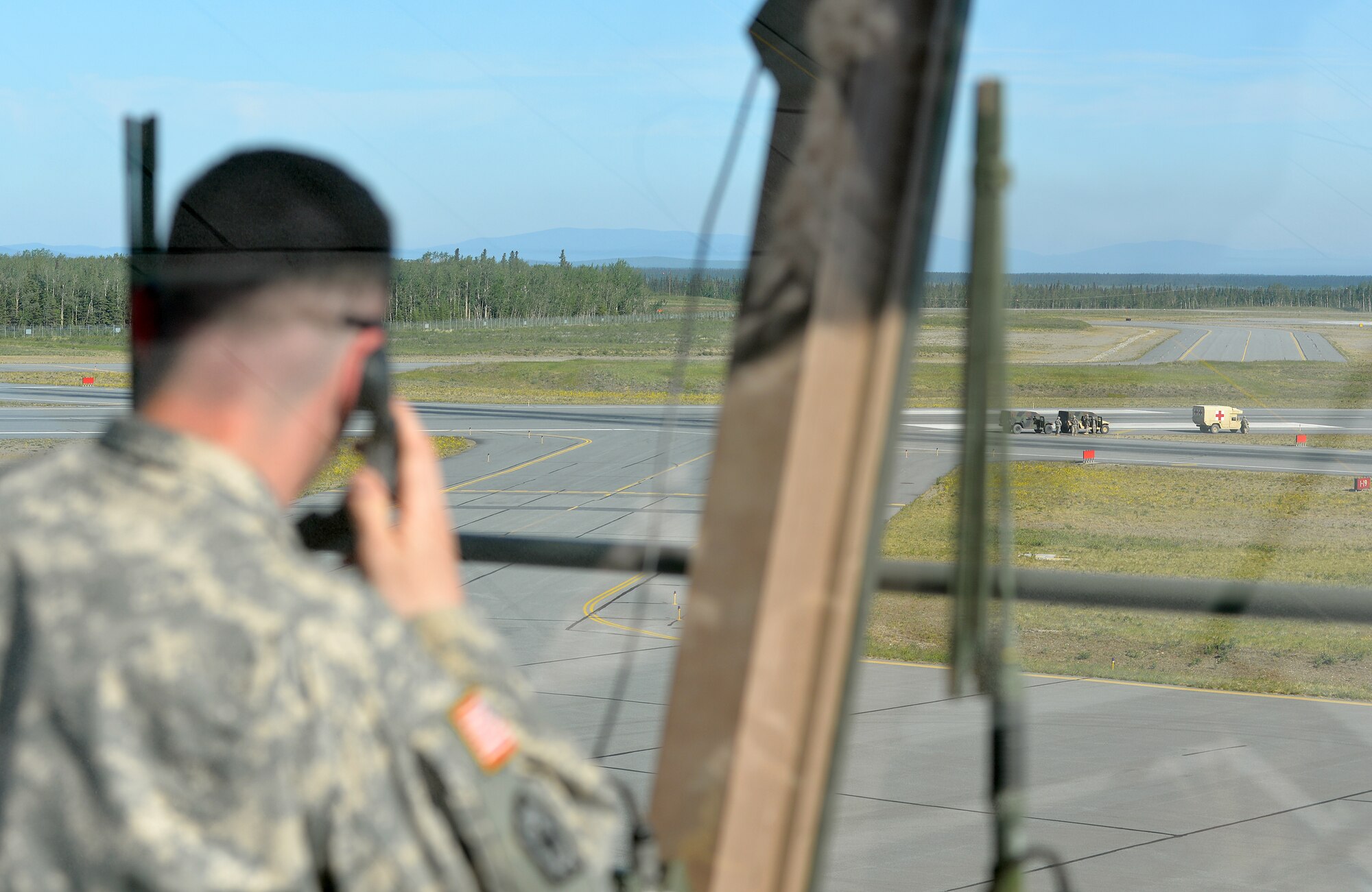 U.S. Army 2nd Lt. Edwin Higginbotham, the battalion assistant plans officer with the 6th Brigade Engineer Battalion, 4th Brigade Combat Team (Airborne), 25th Infantry Division, watches all activity in a drop zone at Allen Army Airfield on Fort Greely, Alaska, to ensure safe conditions for combat engineers who will parachute into area for an airfield seizure scenario as part of Exercise Northern Edge, June 17, 2015. Northern Edge 2015 is Alaska's premier joint training exercise designed to practice operations, techniques and procedures as well as enhance interoperability among the services. Thousands of Airmen, Soldiers, Sailors, Marines and Coast Guardsmen from active duty, reserve and National Guard units are involved. (U.S. Air Force photo by Master Sgt. Karen J. Tomasik/Released)