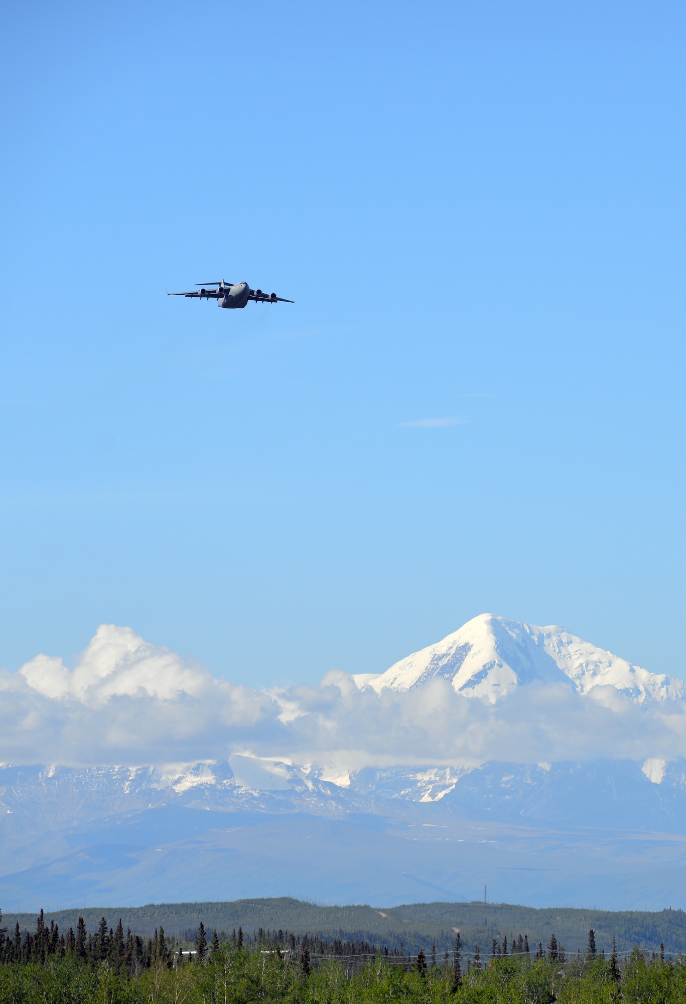 A U.S. Air Force C-17 Globemaster III aircraft passes in front of the Alaska Range as it lines up over Allen Army Airfield at Fort Greely, Alaska, so that 6th Brigade Engineer Battalion, 4th Brigade Combat Team (Airborne), 25th Infantry Division, combat engineers can parachute into the area and execute airfield seizure operations as part of Exercise Northern Edge, June 17, 2015. Northern Edge 2015 is Alaska's premier joint training exercise designed to practice operations, techniques and procedures as well as enhance interoperability among the services. Thousands of Airmen, Soldiers, Sailors, Marines and Coast Guardsmen from active duty, reserve and National Guard units are involved. (U.S. Air Force photo by Master Sgt. Karen J. Tomasik/Released)