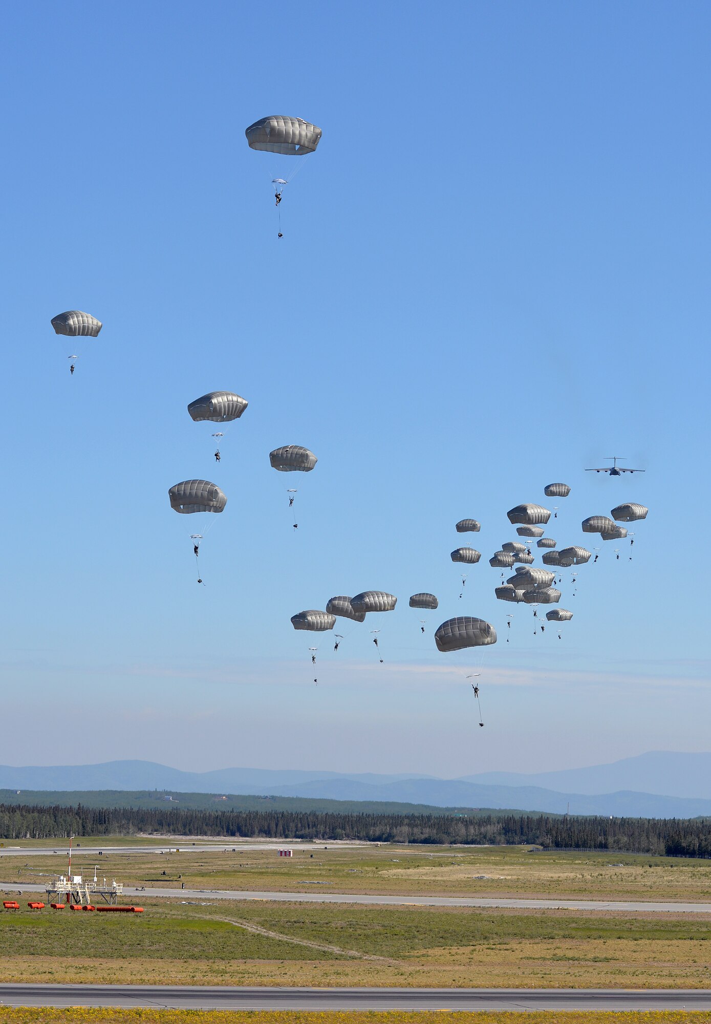 U.S. Army engineers and combat engineers with the 6th Brigade Engineer Battalion, 4th Brigade Combat Team (Airborne), 25th Infantry Division, jump out of a U.S. Air Force C-17 Globemaster III aircraft into Allen Army Airfield at Fort Greely, Alaska, to execute airfield seizure operations as part of Exercise Northern Edge, June 17, 2015. Northern Edge 2015 is Alaska's premier joint training exercise designed to practice operations, techniques and procedures as well as enhance interoperability among the services. Thousands of Airmen, Soldiers, Sailors, Marines and Coast Guardsmen from active duty, reserve and National Guard units are involved. (U.S. Air Force photo by Master Sgt. Karen J. Tomasik/Released)