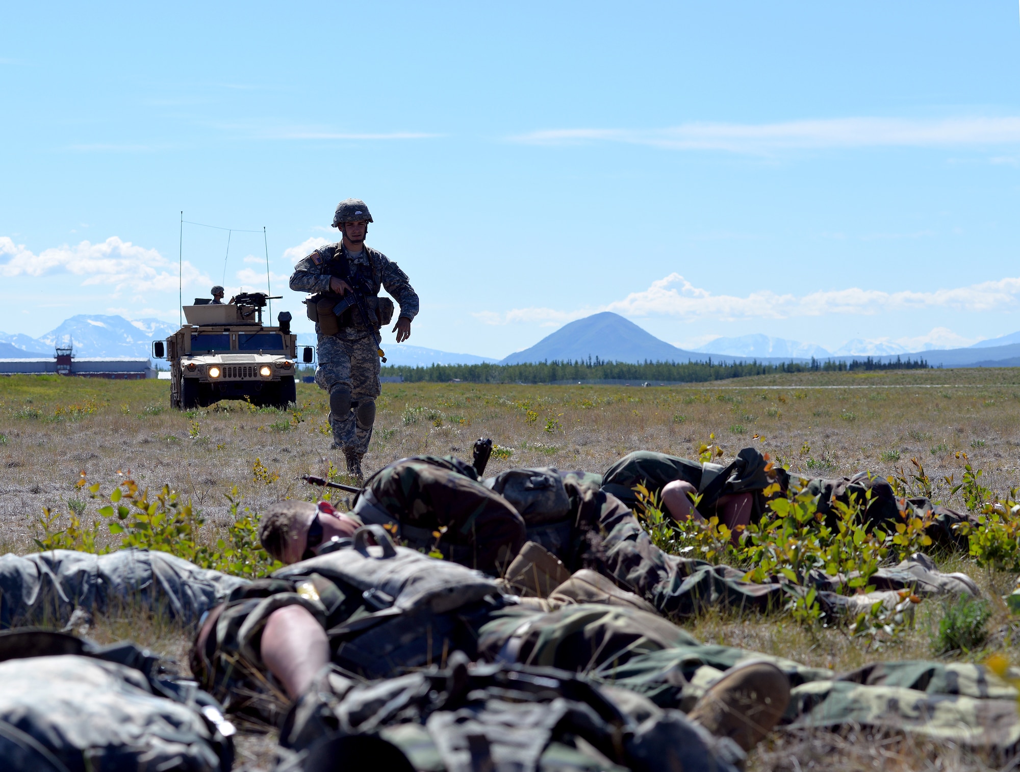 A U.S. Army Soldier with the 6th Brigade Engineer Battalion, 4th Brigade Combat Team (Airborne), 25th Infantry Division, approaches a group of opposing forces at Allen Army Airfield on Fort Greely, Alaska, to attend to a wounded member's injuries and gather information about other opposing forces as part of scenario during Exercise Northern Edge, June 17, 2015. Northern Edge 2015 is Alaska's premier joint training exercise designed to practice operations, techniques and procedures as well as enhance interoperability among the services. Thousands of Airmen, Soldiers, Sailors, Marines and Coast Guardsmen from active duty, reserve and National Guard units are involved. (U.S. Air Force photo by Master Sgt. Karen J. Tomasik/Released)