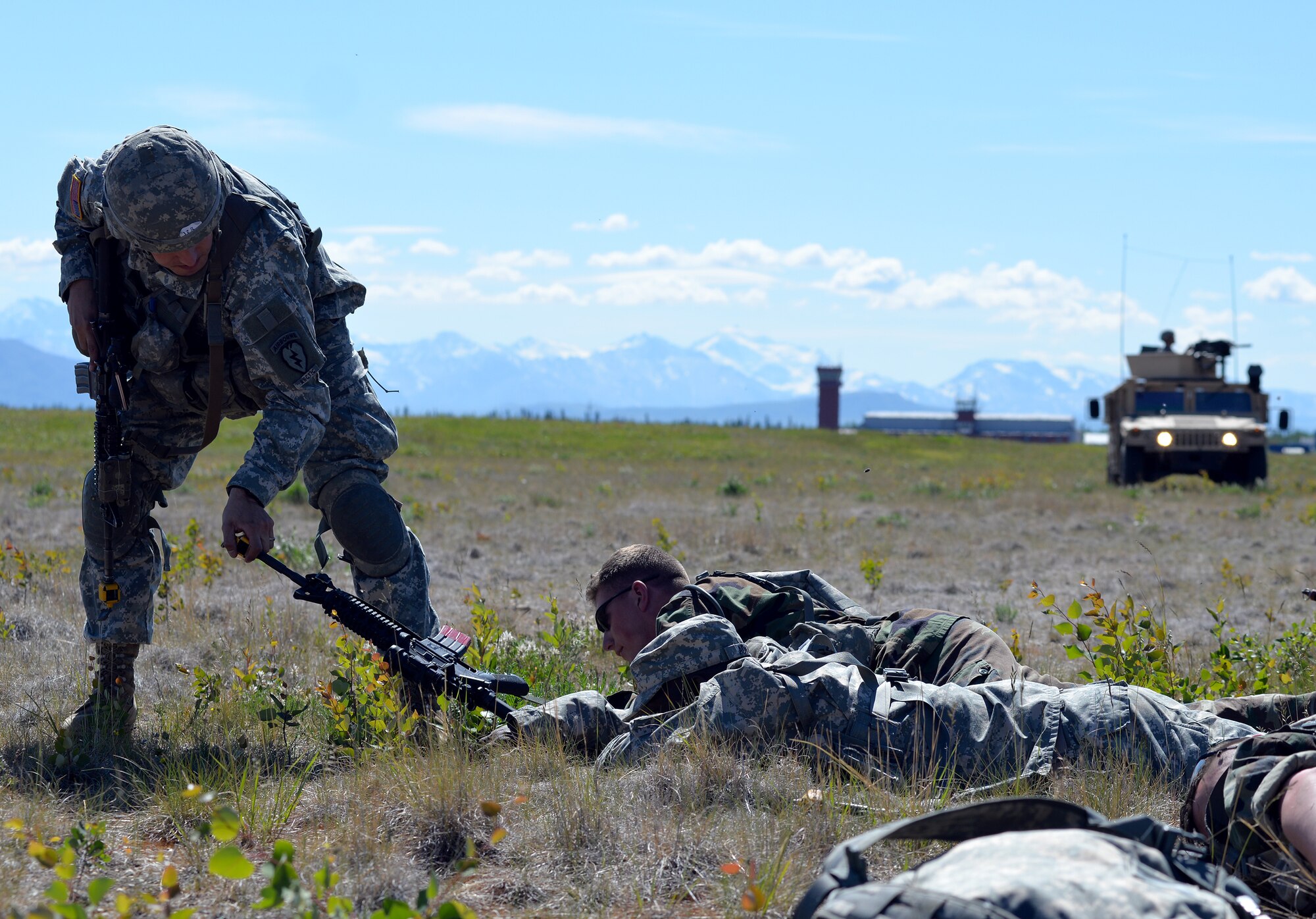 U.S. Army Sgt. Joshua Sanders, a Soldier with the 6th Brigade Engineer Battalion, 4th Brigade Combat Team (Airborne), 25th Infantry Division, removes a weapon from the reach of injured opposing forces at Allen Army Airfield on Fort Greely, Alaska, as his team prepares to attend to the wounded member's injuries and gather information about other opposing forces as part of scenario during Exercise Northern Edge, June 17, 2015. Northern Edge 2015 is Alaska's premier joint training exercise designed to practice operations, techniques and procedures as well as enhance interoperability among the services. Thousands of Airmen, Soldiers, Sailors, Marines and Coast Guardsmen from active duty, reserve and National Guard units are involved. (U.S. Air Force photo by Master Sgt. Karen J. Tomasik/Released)