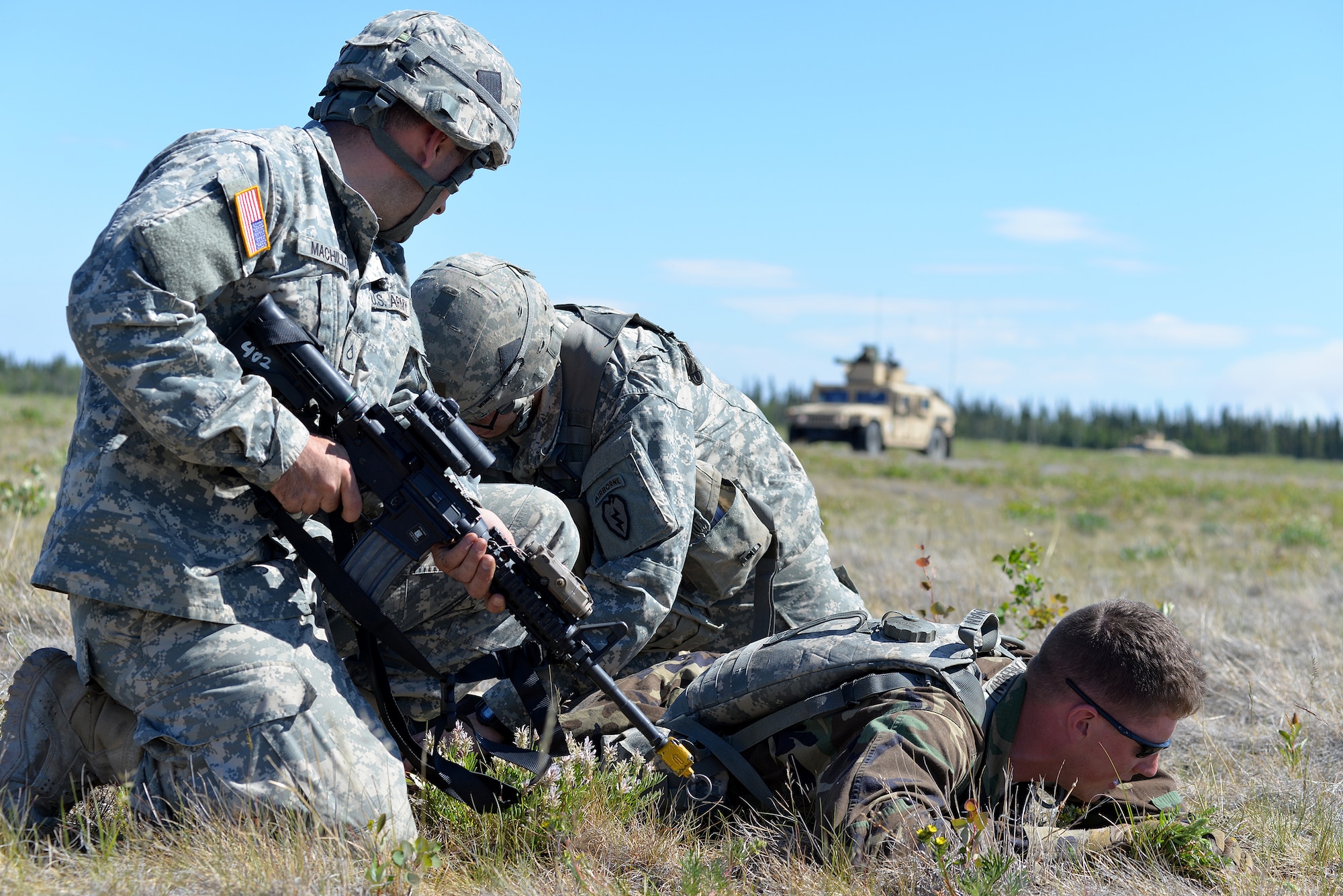 U.S. Army Pfc. Christopher Machillo and Spc. Stephen Wendel, Soldiers with the 6th Brigade Engineer Battalion, 4th Brigade Combat Team (Airborne), 25th Infantry Division, search for weapons and intel an injured opposing forces member may possess at Allen Army Airfield on Fort Greely, Alaska, as their team prepares to attend to the wounded member's injuries and gather information about other opposing forces as part of scenario during Exercise Northern Edge, June 17, 2015. Northern Edge 2015 is Alaska's premier joint training exercise designed to practice operations, techniques and procedures as well as enhance interoperability among the services. Thousands of Airmen, Soldiers, Sailors, Marines and Coast Guardsmen from active duty, reserve and National Guard units are involved. (U.S. Air Force photo by Master Sgt. Karen J. Tomasik/Released)