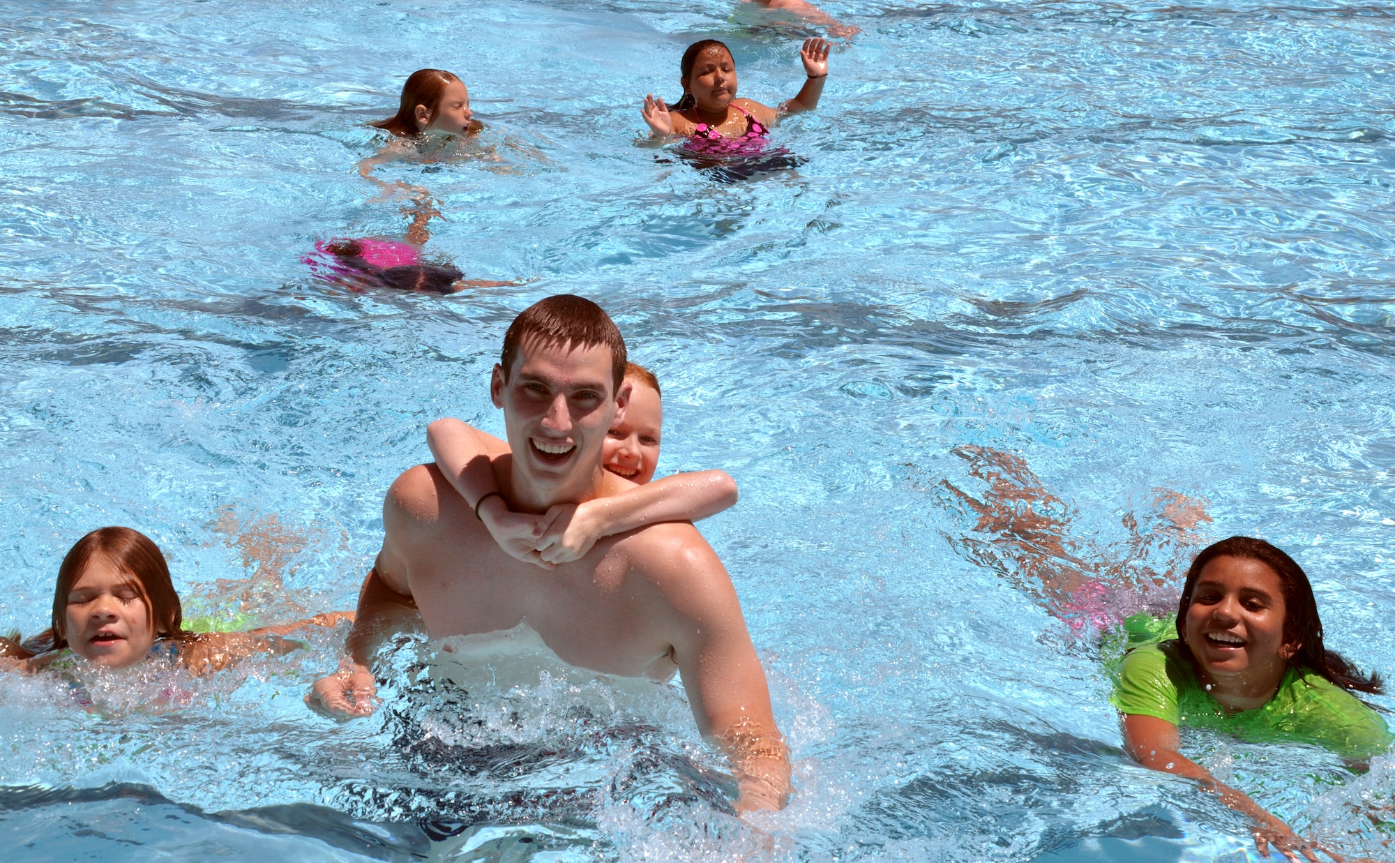 1st Lt. Rocque Gartland, a 3rd Flying Training Squadron instructor pilot, plays sharks and minnows with children from the “girl’s week” of Camp Tomahawk June 8 in the pool at Vance Air Force Base, Oklahoma. Team Vance has worked with the Enid Chamber of Commerce to provide a summer camp for children for the past 25 years. (U.S. Air Force photo / 2nd Lt. Isabel Crump)