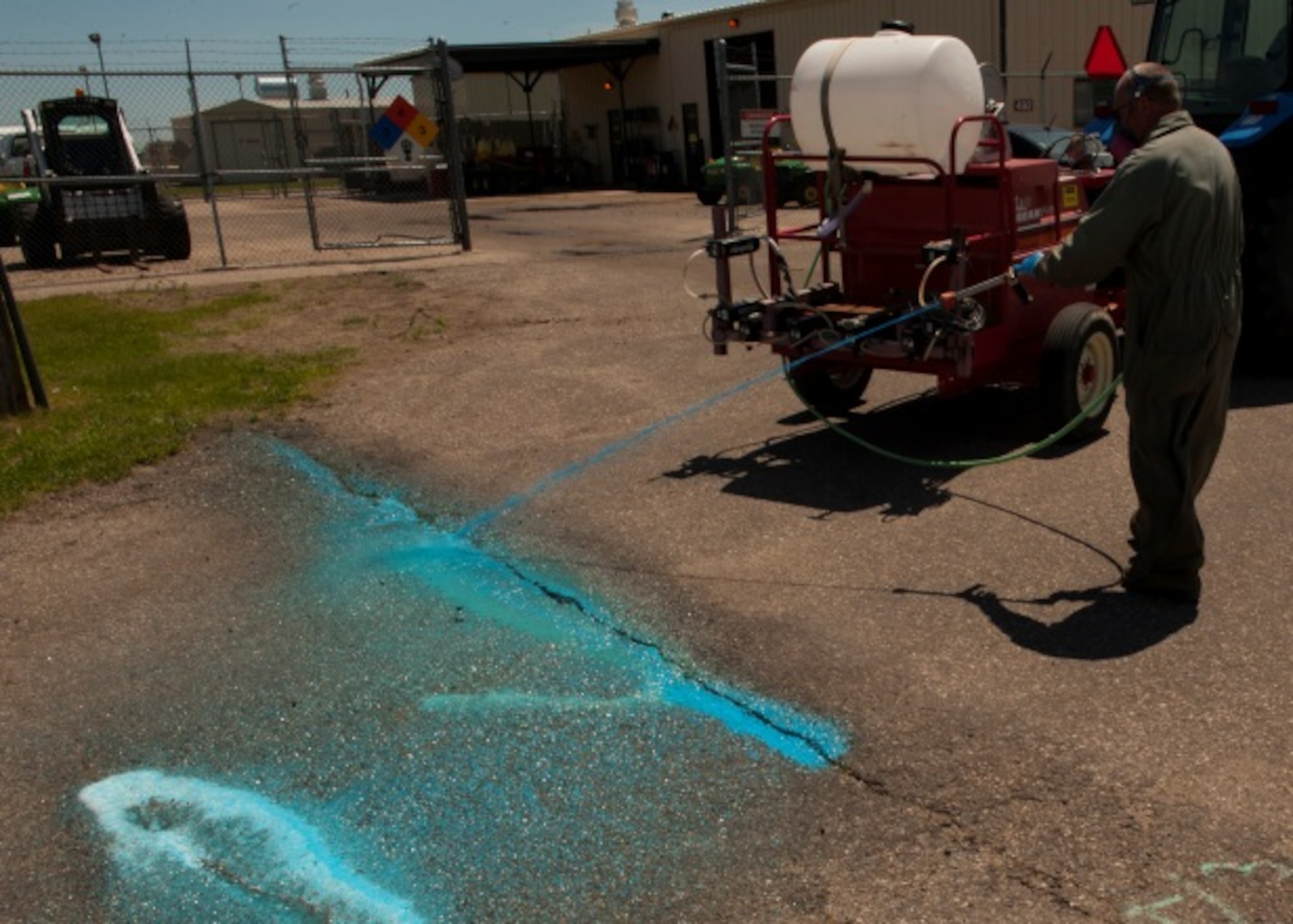 Lester Nicholas, pest management foreman, sprays a non-harmful weed killer at Minot Air Force Base, N.D., June 18, 2015. Pest Management supports the 5th Bomb Wing flying mission by eliminating flight line weeds as well as weeds around the base. (U.S. Air Force photo/Airman 1st Class Christian Sullivan)