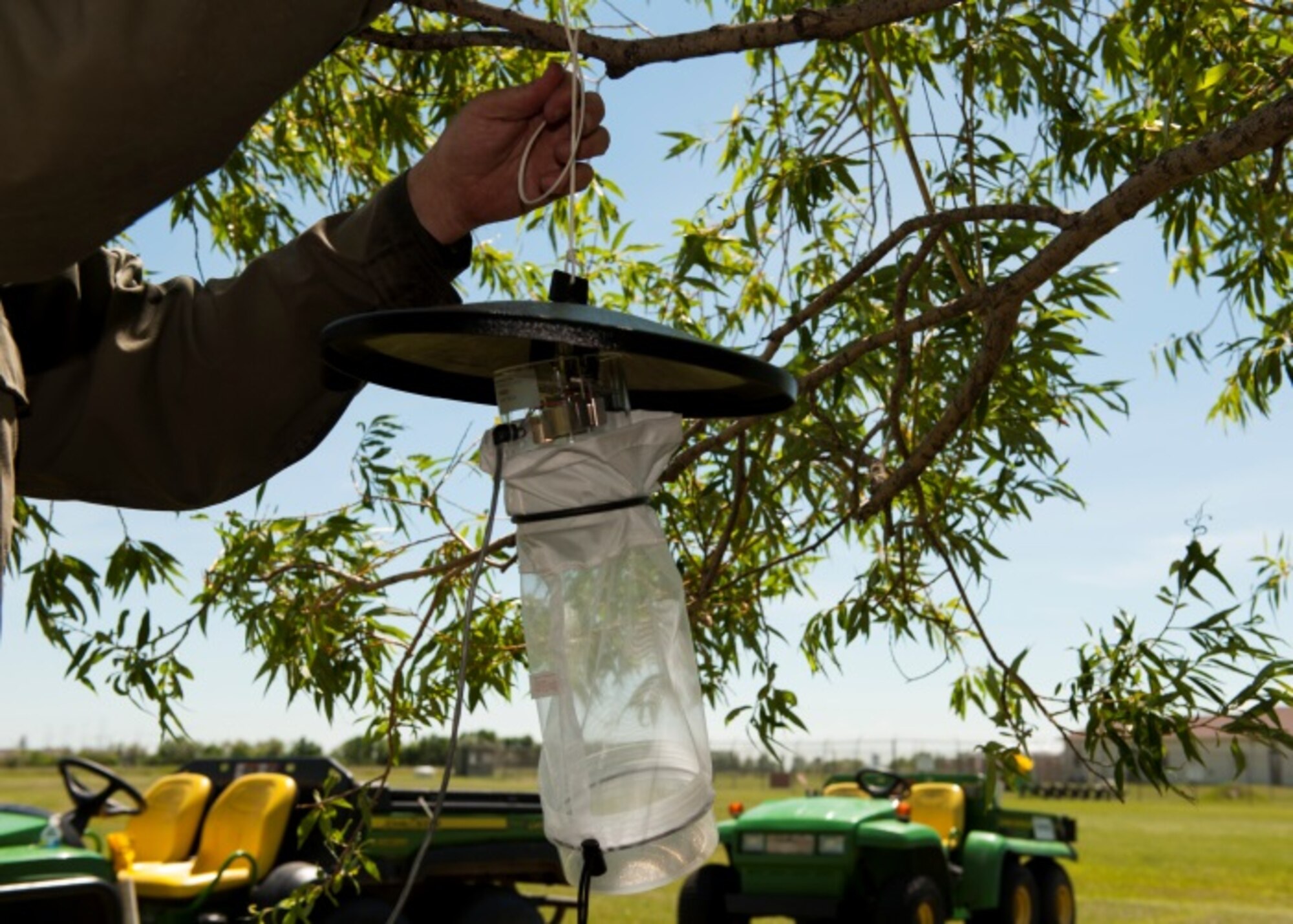 Lester Nichols, pest management foreman, hangs up a mosquito trap at Minot Air Force Base, N.D., June 18, 2015. Pest Management works to protect the health and morale of base personnel through a comprehensive mosquito control program. (U.S. Air Force photo/Airman 1st Class Christian Sullivan)