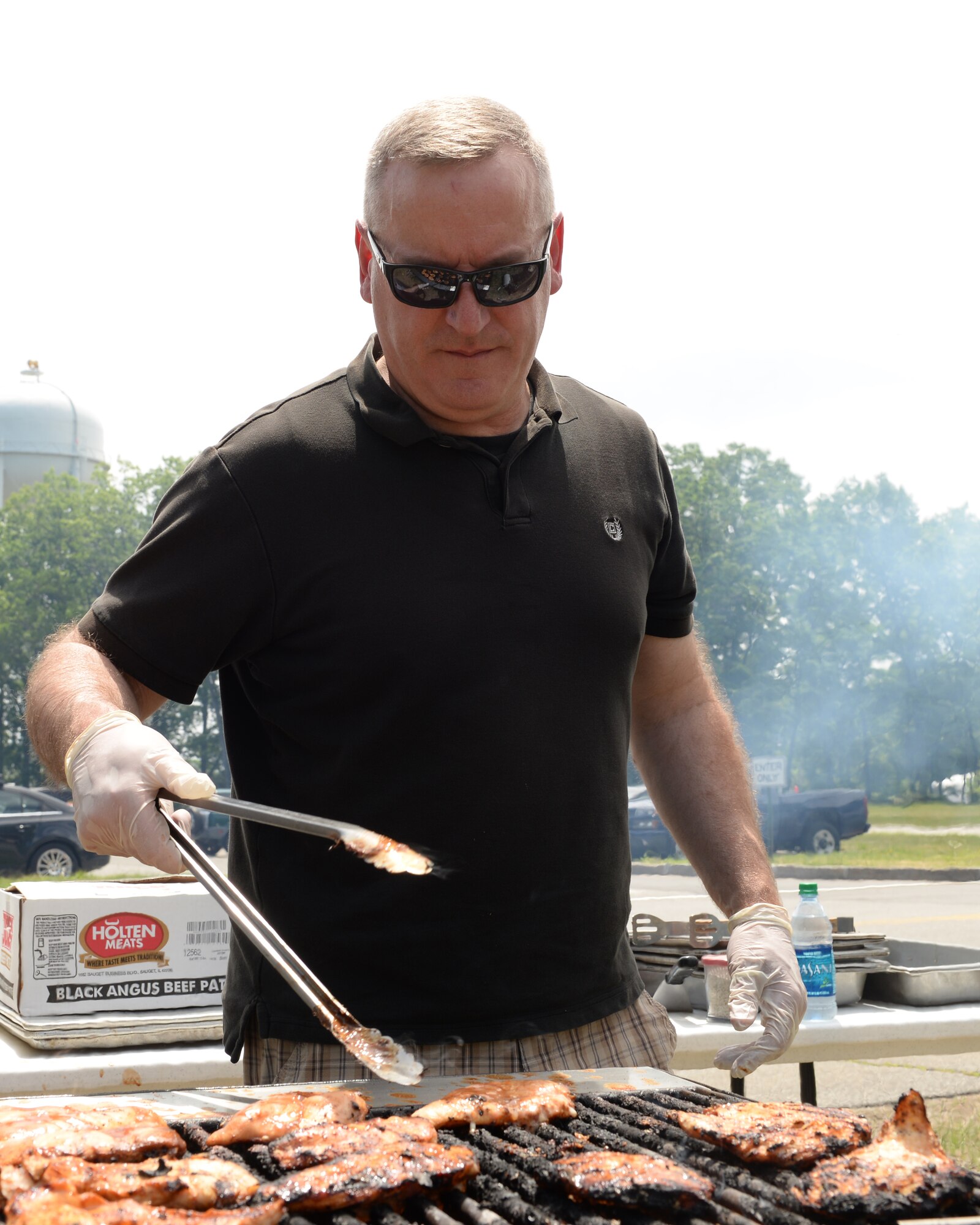 157th Air Refueling Wing Command Chief Master Sgt. Jamie Lawrence cooks food during the Annual Retiree Day on June 17, 2015 at Pease Air National Guard Base, N.H.  (U.S. Air National Guard photo by Staff Sgt. Curtis J. Lenz) 