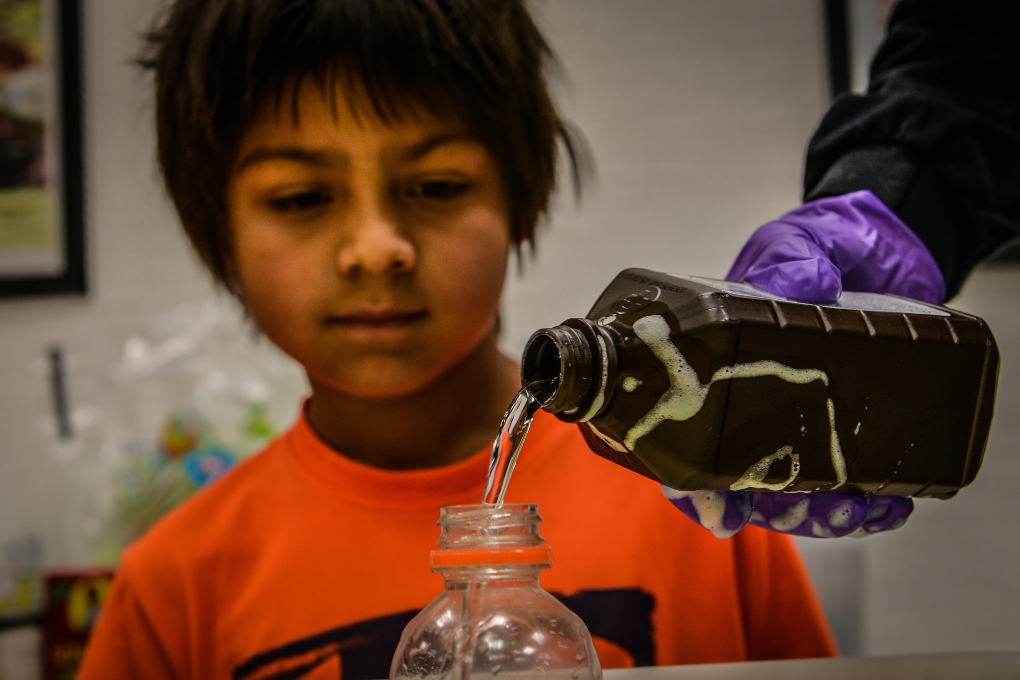A student watches as Vikramjeet Rathur, Ramstein Youth Center programs assistant, pours hydrogen peroxide into a bottle during a science experiment June 17, 2015, at Ramstein Air Base, Germany.  The RYC was awarded the first ever Science, Technology, Engineering and Math which will be used for improvement in the areas of both education and in the progress of structural projects within schools. (U.S. Air Force photo/Senior Airman Nicole Sikorski) 