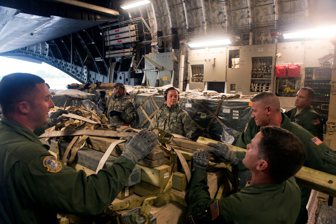 U.S airmen offload equipment from a C-17 Globemaster III aircraft ...