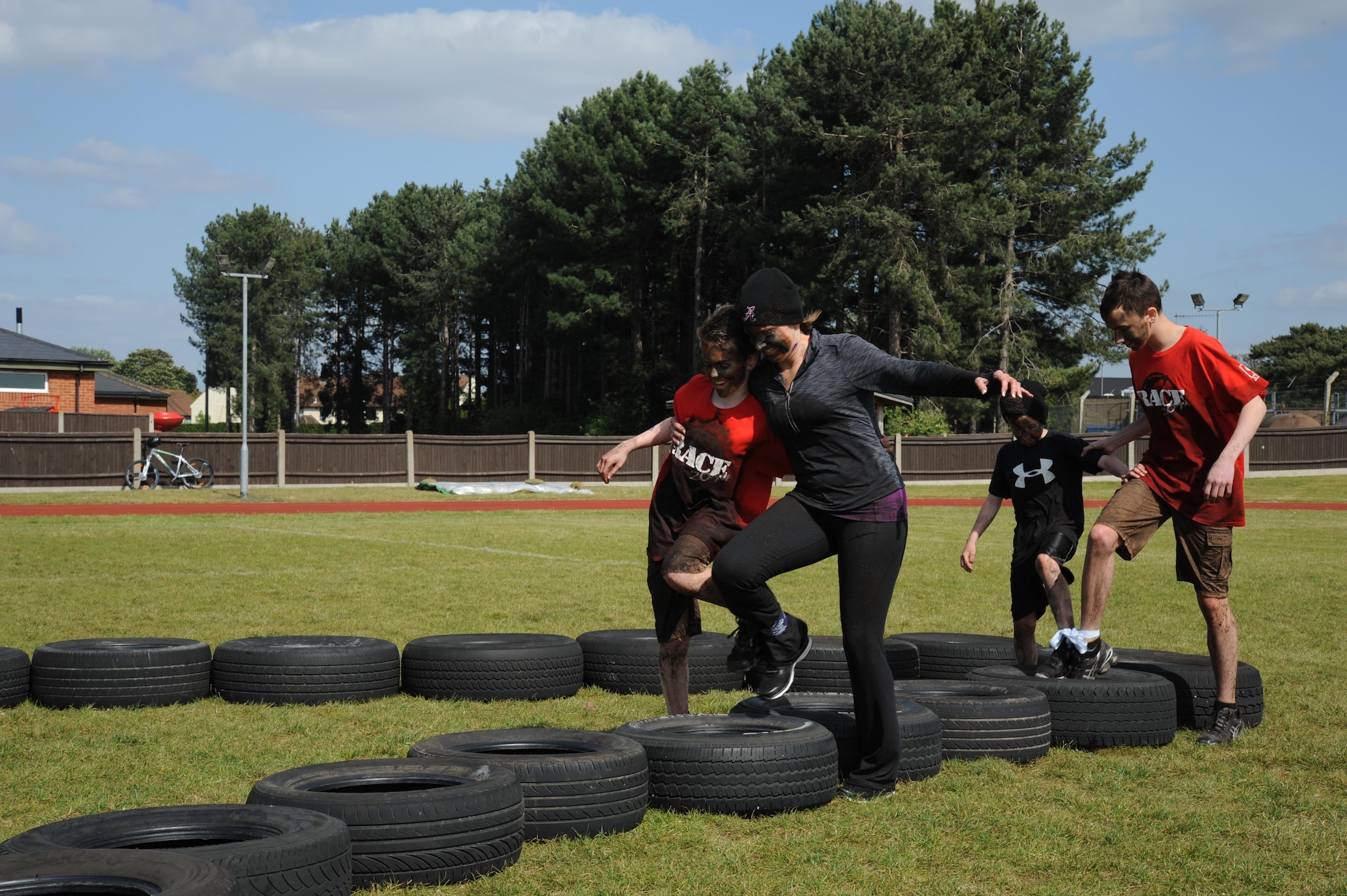 A mother and her three sons navigate through the three-legged tire obstacle during the “Momster Mash” May 16, 2015, at the Heritage Park sports fields on RAF Mildenhall, England. The event was hosted by the 352nd Special Operations Wing Preservation of Force and Families team and was aimed at providing an opportunity for mothers and their sons – traditionally a relationship with difficulties -- to bond. (U.S. Air Force photo by Tech. Sgt. Stacia Zachary)