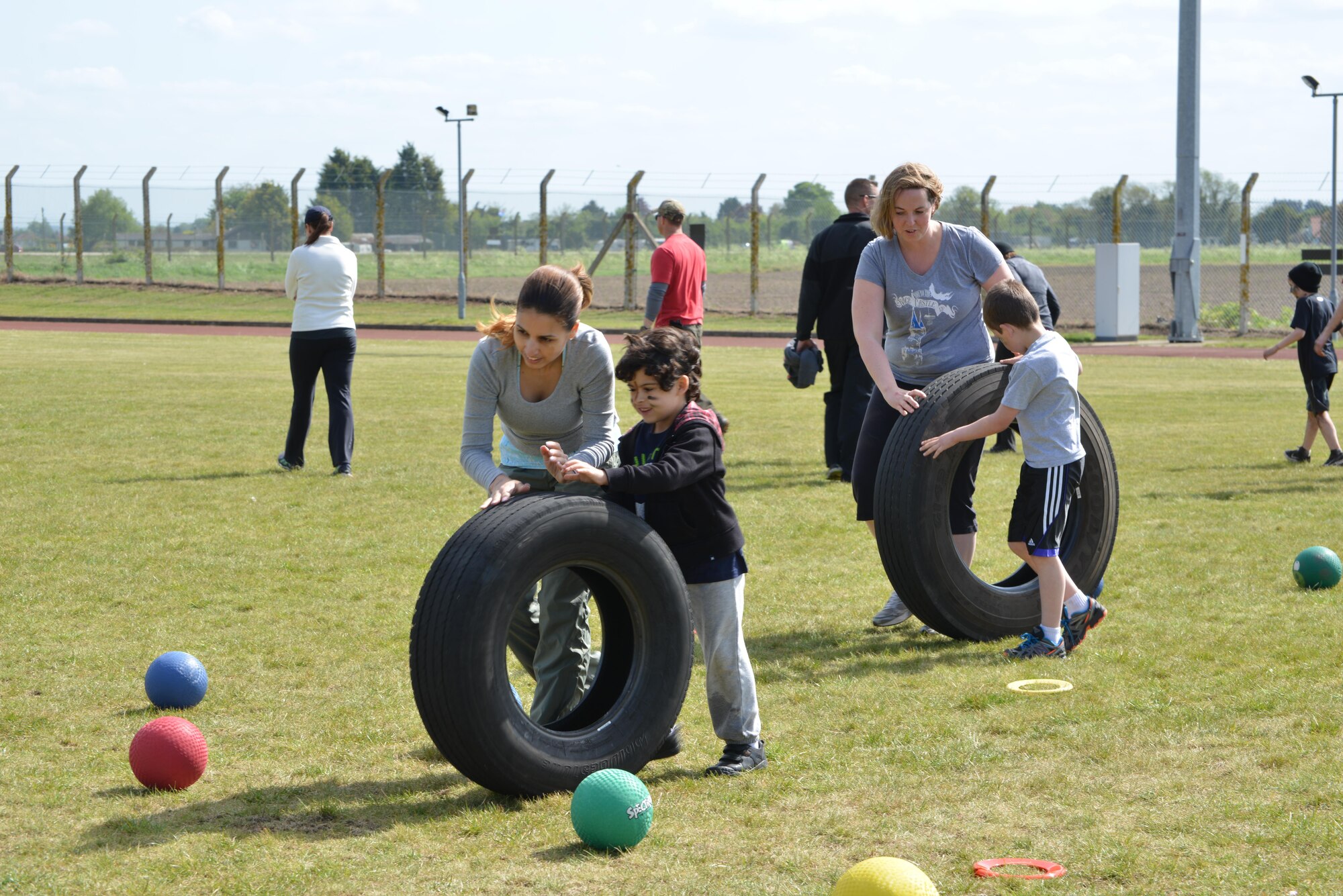 Mothers and their sons roll a tire through an obstacle course during the “Momster Mash” May 16, 2015, at the Heritage Park sports fields on RAF Mildenhall, England. The event was hosted by the 352nd Special Operations Wing Preservation of Force and Families team and was aimed at providing an opportunity for mothers and their sons – traditionally a relationship with difficulties -- to bond. (U.S. Air Force photo by Tech. Sgt. Stacia Zachary)