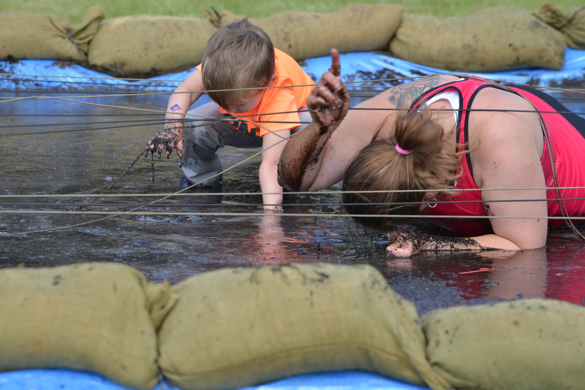 A mother and her son perform the mud pit low crawl challenge during the “Momster Mash” May 16, 2015, at the Heritage Park sports fields on RAF Mildenhall, England. The event was hosted by the 352nd Special Operations Wing Preservation of Force and Families team and was aimed at providing an opportunity for mothers and their sons – traditionally a relationship with difficulties -- to bond. (U.S. Air Force photo by Tech. Sgt. Stacia Zachary)