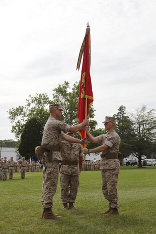 U.S. Marine Col. James M. Bright, Marine Corps Security Force Regiment outgoing commander (right), hands the regimental colors to Col. John W. Evans Jr., incoming regimental commanding officer (left), during a change-of-command ceremony aboard Naval Weapons Station Yorktown, Va., June 19, 2015. The exchange of the regimental colors represents the passing of command from the outgoing to the incoming commander. (U.S. Marine Corps photo by Sgt. Esdras Ruano/Released)