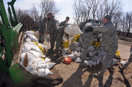 Air Force Master Sgt. David Bush, of the 119th Civil Engineer Squadron,
right, is one of several members of a North Dakota National Guard quick
response force team throwing sandbags into the bucket on a farm tractor
April 12, 2011, near Enderlin, N.D. The QRF is responding to a request from
a farm resident through the Cass County Emergency Operations Center for
sandbag assistance to create a flood levee barrier to rising water around
his house. The tractor is one of the few vehicles light enough and high
enough to cross a precarious section of flooded roadway leading to the
farmstead without damaging the road.