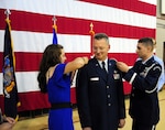 New York Air National Guard Maj. Gen. Anthony German, the commander of the 5,900-member New York Air National Guard, receives his two-star rank from his daughter Beckah and son, Air National Guard Capt. Joshua German, during his promotion and change of command ceremony at New York State Division of Military and Naval Affairs headquarters in Latham, New York on June 22, 2015. 