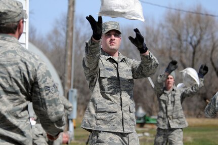 Air Force Staff Sgt. Paul Williams and Air Force Staff Sgt. Sam Wagner, both 
of the 119th Civil Engineer Squadron, toss sandbags along a line of Soldiers 
and Airmen who are members of a North Dakota National Guard quick response 
force team April 14, 2011, near Kindred, N.D. The QRF were responding to a 
request from a rural farm resident, living along the Sheyenne River, for 
sandbag assistance to create a flood levee barrier to rising water around his 
house.  As of April 14, more than 500 N.D. National Guard Airmen and Soldiers 
were conducting flood operations in North Dakota, with the vast majority in 
Cass County.