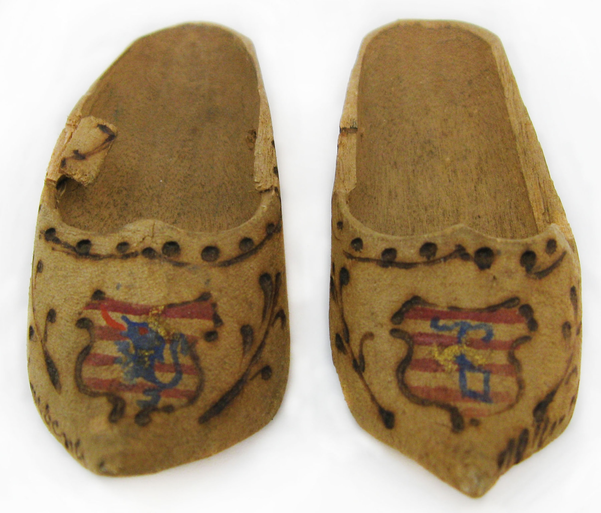 These souvenir miniature wooden shoes are approximately 7/8 inches high by 1-3/16 inches wide by 3 inches long. The design was both painted onto and burned into each shoe. (U.S. Air Force photo)
