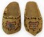 These souvenir miniature wooden shoes are approximately 7/8 inches high by 1-3/16 inches wide by 3 inches long. The design was both painted onto and burned into each shoe. (U.S. Air Force photo)