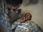New York Army National Guard Pfc. Lee McDonald, from Staten Island, practices combat lifesaver techniques on Spc. Kadeem Fowler, a Troy resident,  during annual training at Fort Drum June 17, 2015. The two Soldiers are members of the New York National Guard 42nd Infantry Division Headquarters and Support Company.