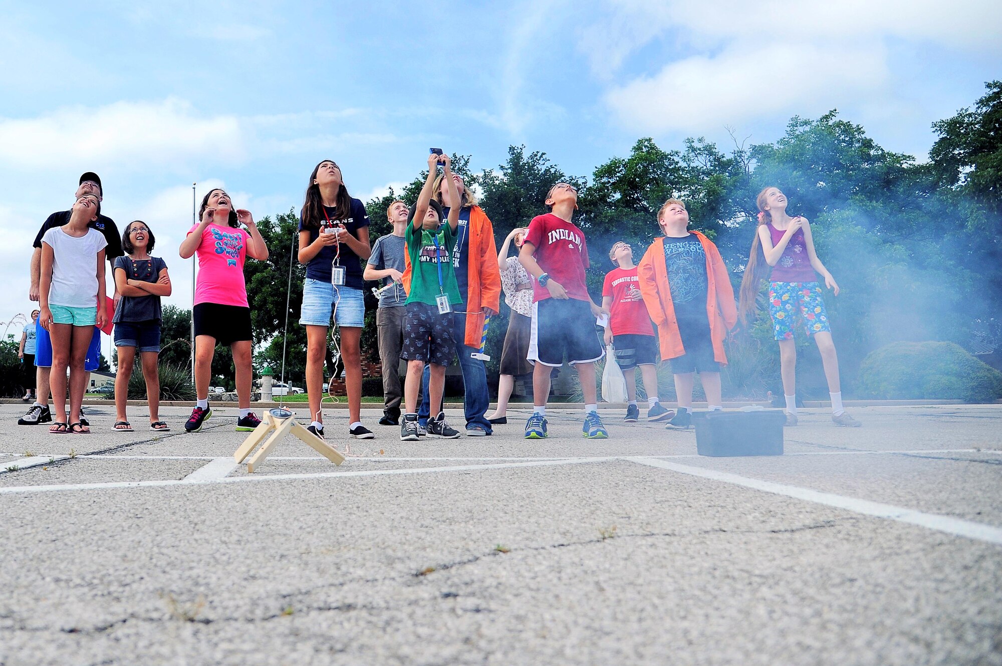 Participants of the 17th Force Support Squadron Youth Programs Science Camp watch a rocket they launched on Goodfellow Air Force Base, Texas, June 19, 2015. Goodfellow held the science camp in response to the nation’s youth showing an increased interest in science, technology, engineering and mathematics. (U.S. Air Force photo by Tech. Sgt. Austin Knox/Released)