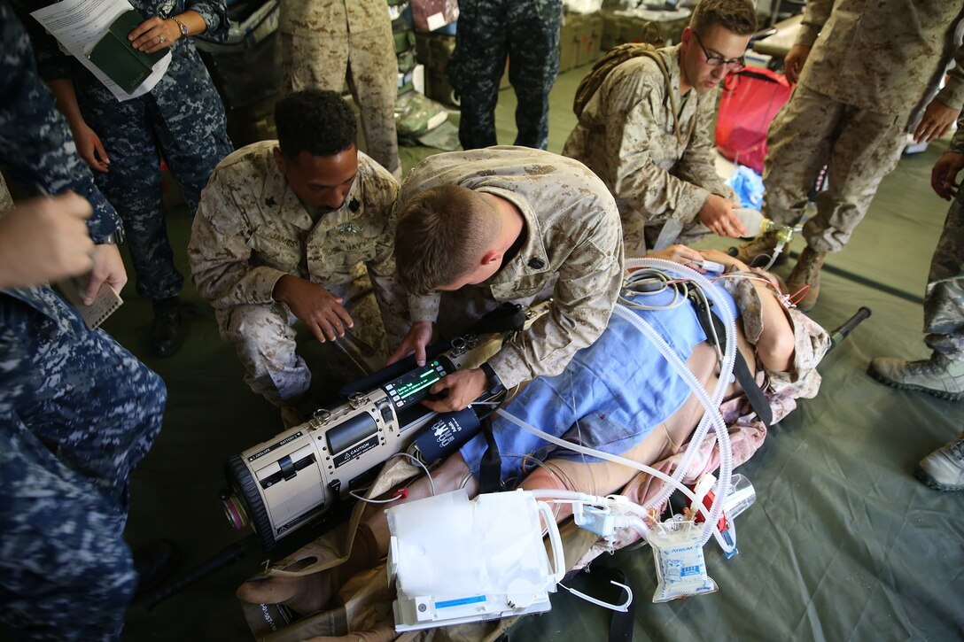 U.S. Navy field medical service technicians with Company C, 1st Medical Battalion, 1st Marine Logistics Group, I Marine Expeditionary Force, along with Navy Health Service Augmentation Program personnel prepare a mock casualty for evacuation during a field casualty training exercise at the Balboa Symposium, Naval Medical Center San Diego, June 18, 2015. The hospital corpsmen and field medical service technicians worked together to operate a field shock trauma and forward resuscitative surgical suite.
