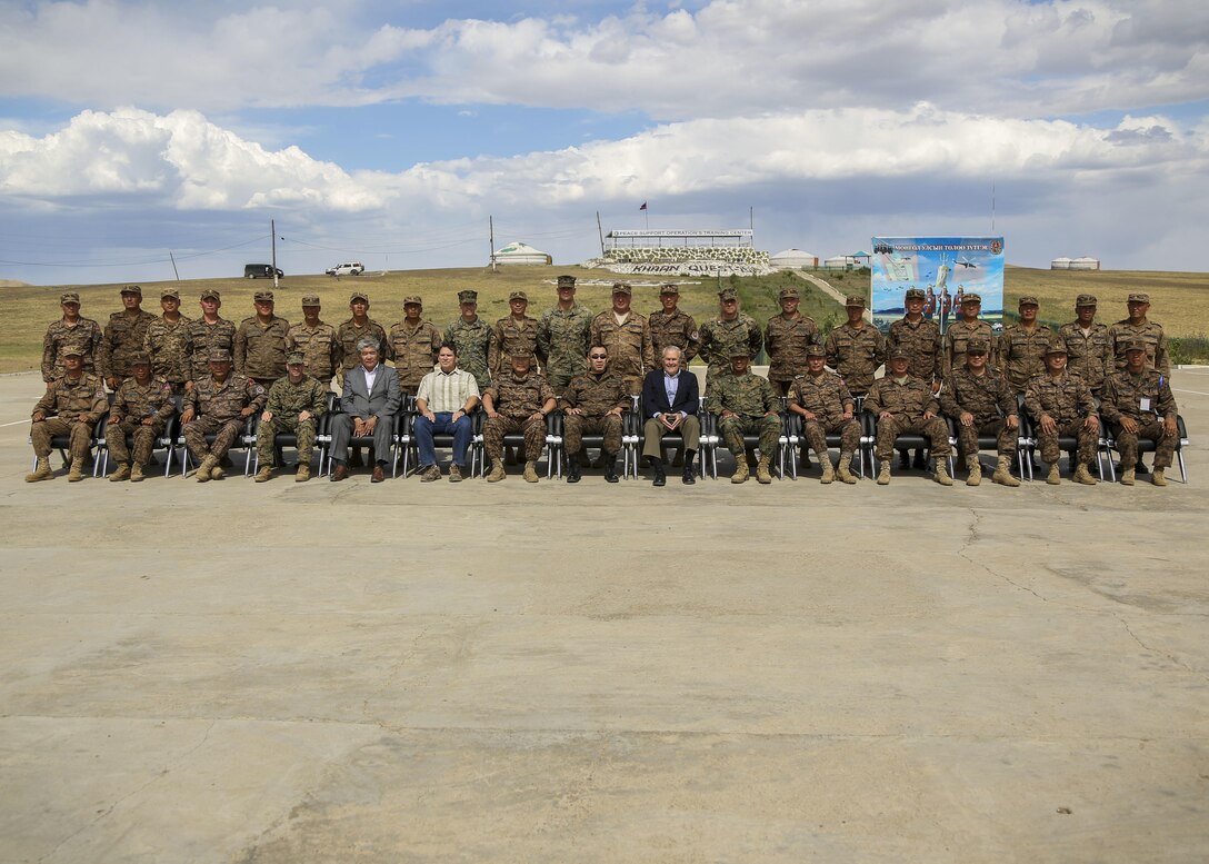 Mongolian Armed Forces pose for a photo with former U.S. Secretary of Defense Donald Rumsfeld and a panel of distinguished guests visiting Five Hills Training Area during Khaan Quest 2015 in Tavantolgoi, Mongolia, June 22, 2015. Khaan Quest is a regularly scheduled, multinational exercise hosted annually by Mongolian Armed Forces and co-sponsored by U.S. Army, Pacific, and U.S. Marine Corps Forces, Pacific. KQ15 is the latest in a continuing series of exercises designed to promote regional peace and security. This year marks the 13th iteration of this training event.