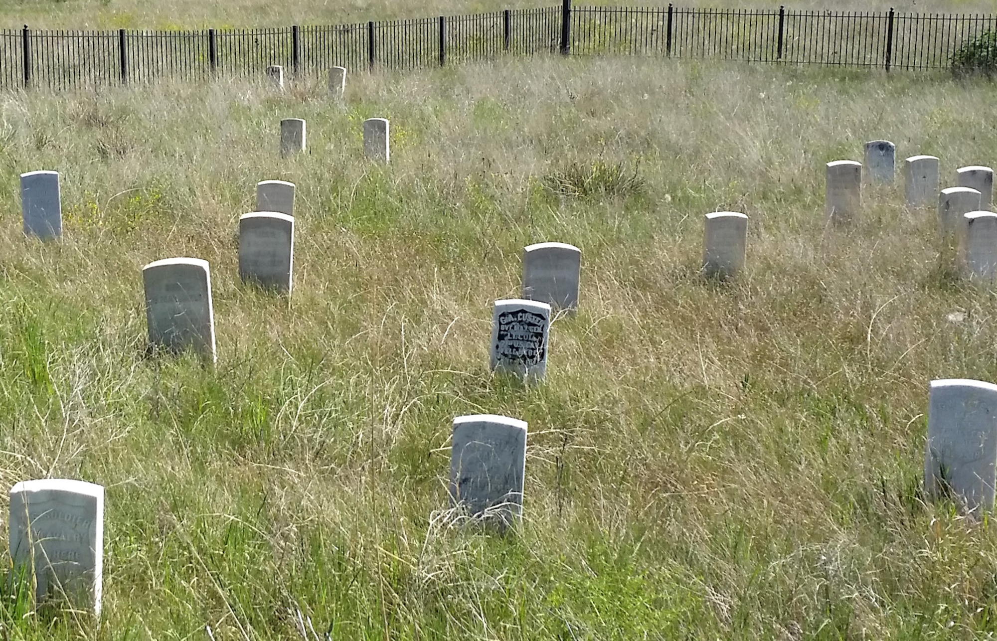 A special black-plated marker, center, on Last Stand Hill indicates where Lt. Col. George A. Custer, commander of the Seventh Cavalry regiment, died June 25, 1876, at the Battle of Little Bighorn near present-day Garryowen, Mont.  In 1890, the Army erected 249 white marble headstones across the battlefield to show where each of Custer’s men had fallen during the battle. In 1999 the National Park Service began placing red granite markers at known Cheyenne and Lakota casualty sites to help give a balanced interpretation of the conflict. (U.S. Air Force photo/John Turner)
