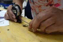 Candice Brown, 341st Maintenance Operation Squadron Precision Measurement Equipment Laboratory technician, checks the dial integrator and uses the universal measuring machine to sharpen knife edges June 23, 2015, at Malmstrom  Air Force Base, Mont. The PMEL shop supports the 341st Missile Wing, 19th RED HORSE, and provides lateral support to local bases. (U.S. Air Force photo/Chris Willis)