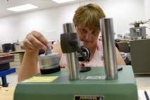 Candice Brown, 341st Maintenance Operation Squadron Precision Measurement Equipment Laboratory technician, checks the dial integrator and uses the universal measuring machine to sharpen knife edges June 23, 2015, at Malmstrom  Air Force Base, Mont. The PMEL shop supports the 341st Missile Wing, 19th RED HORSE, and provides lateral support to local bases. (U.S. Air Force photo/Chris Willis)