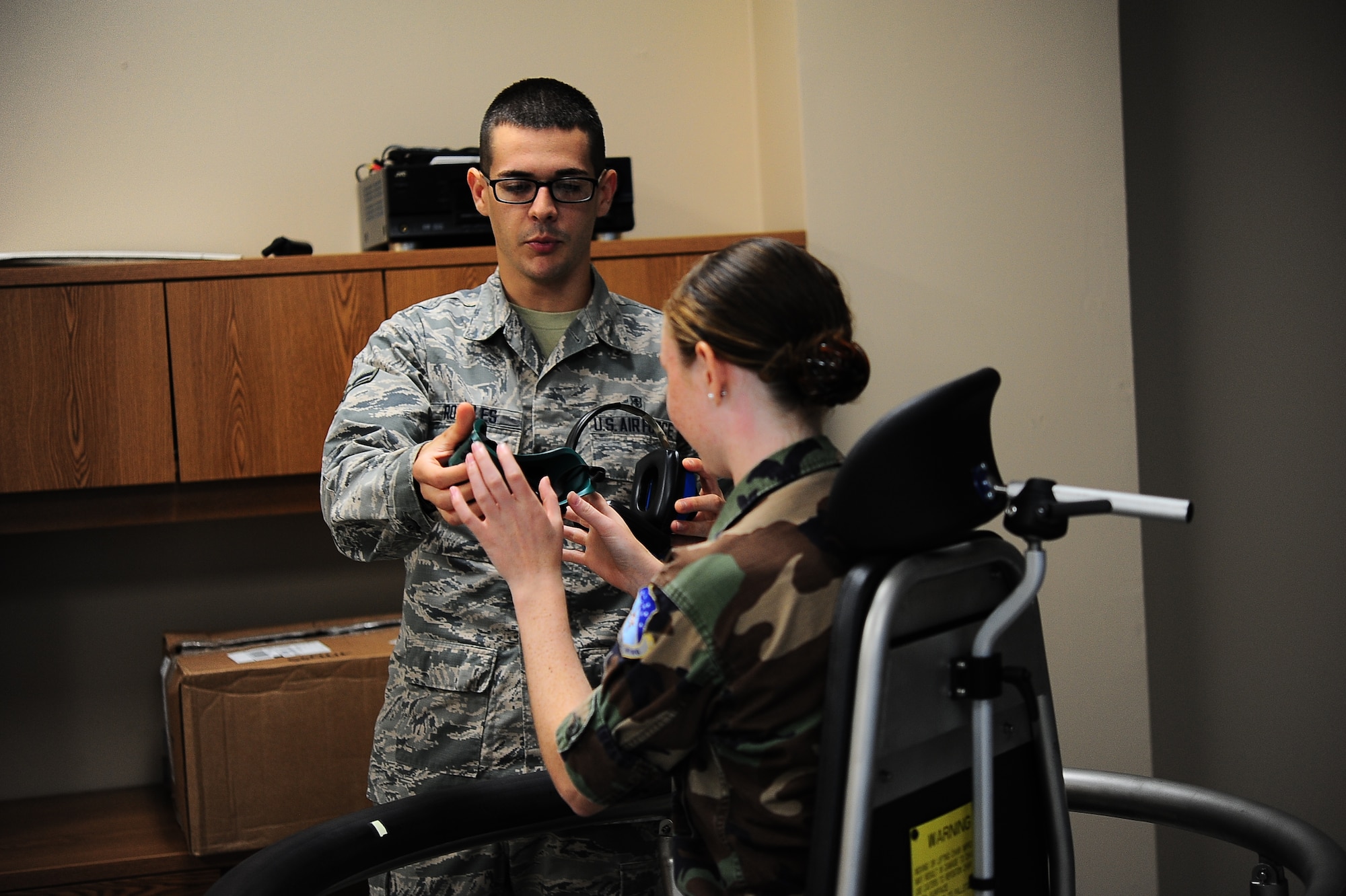 Airman 1st Class Jonathan Rosales, 14th Medical Group Aerospace Physiology Technician, hands a blacked out mask to a Civil Air Patrol Cadet June 22 before providing a lesson on spatial disorientation to the cadet on Columbus Air Force Base, Mississippi. Civil Air Patrol cadets from across the country traveled to Columbus Air Force Base June 22-26 to participate in the 2015 Specialized Undergraduate Pilot Training Familiarization Course. (U.S. Air Force photo/Airman Daniel Lile)
