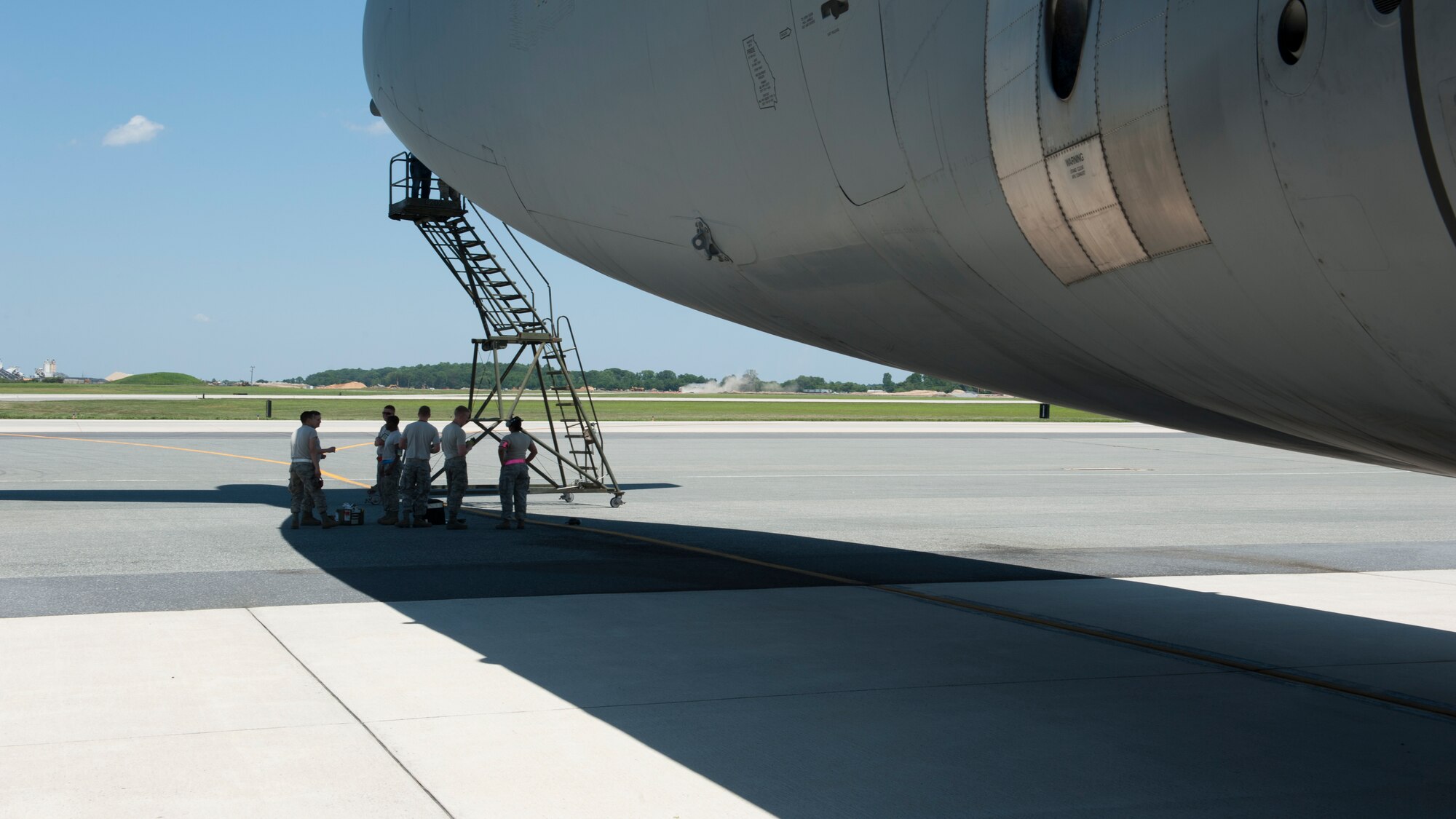 Maintainers from the 436th and 512th Maintenance Groups take advantage of the shade provided by the tail section of a C-5M Super Galaxy June 22, 2015, at Dover Air Force Base, Del. Maintainers regularly have to work outside in excessive heat. (U.S. Air Force photo/Airman 1st Class Zachary Cacicia)