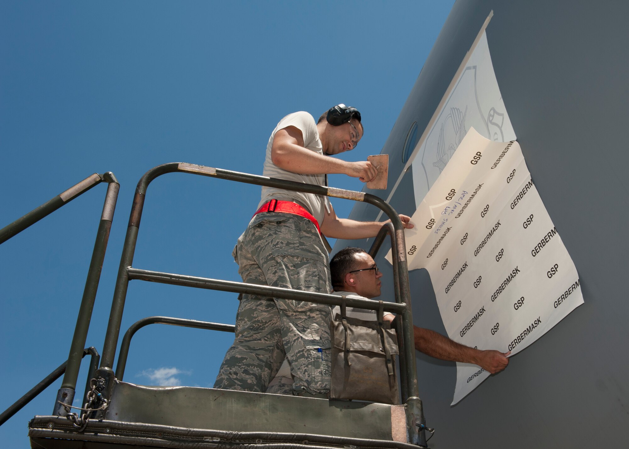Senior Airman Joseph Carmona and Senior Airman Daniel Soto, both structural maintenance mechanics from the 436th Maintenance Squadron, apply an Air Force Reserve Command stencil to the side of a C-5M Super Galaxy June 22, 2015, at Dover Air Force Base, Del. Carmona and Soto also applied an Air Mobility Command stencil to the aircraft. (U.S. Air Force photo/Airman 1st Class Zachary Cacicia)