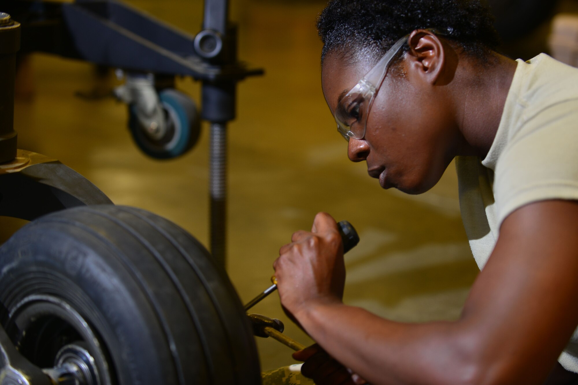 U.S. Army Pvt. Shateequa Adams, 128th Aviation Brigade Advanced Individual Training student, changes a tire for a UH-60 Blackhawk’s landing gear at Fort Eustis, Va., June 18, 2015. Throughout AIT, students practice their duty skill set as well as aviation safety, Army values, physical fitness, warrior tasks and battle drills. (U.S. Air Force photo by Staff Sgt. Natasha Stannard/Released)