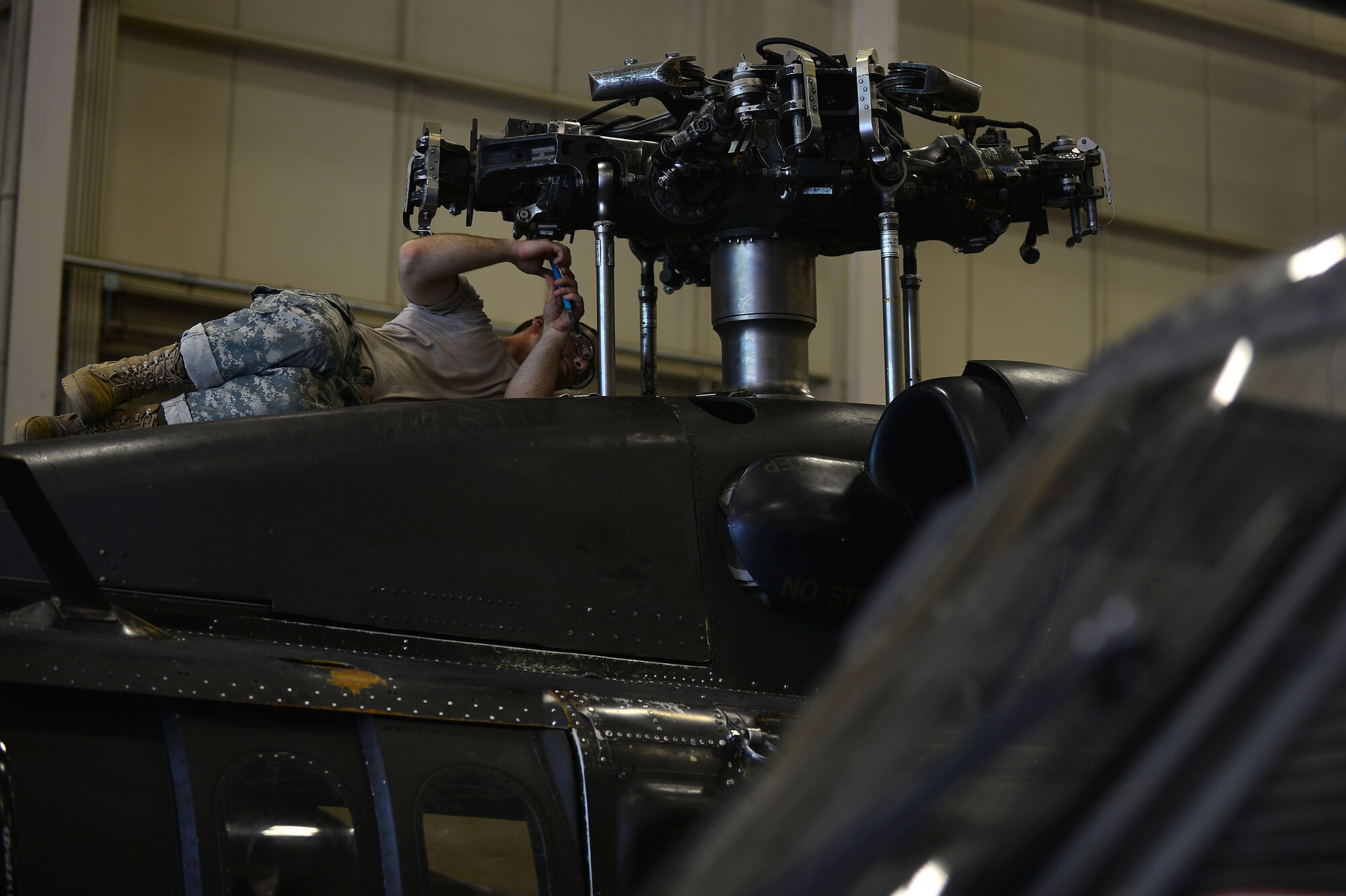 U.S. Army Pvt. Nikkolaus Carr, 128th Aviation Brigade Advanced Individual Training student, works on a UH-60 Blackhawk’s main rotator rotor hub at Fort Eustis, Va., June 18, 2015. The 128th Avn. Bde. trains on a variety of the aircraft’s maintenance, hydraulic and rotor systems as well as trouble shooting practices. (U.S. Air Force photo by Staff Sgt. Natasha Stannard/Released)