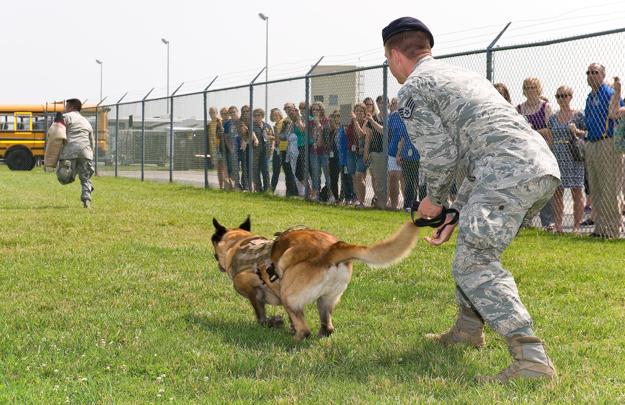 Staff Sgt. Craig Eveland, military working dog handler, right, releases MWD Cuervo to attack Senior Airman Matthew Dubon, left, MWD handler, all assigned to the 436th Security Forces Squadron, during a training demonstration June 12, 2015, on Dover Air Force Base, Del. Teachers from George S. Welch Elementary and Dover Air Force Base Middle schools toured base facilities, met with personnel and learned about the daily operations at Dover AFB.(U.S. Air Force photo/Roland Balik)