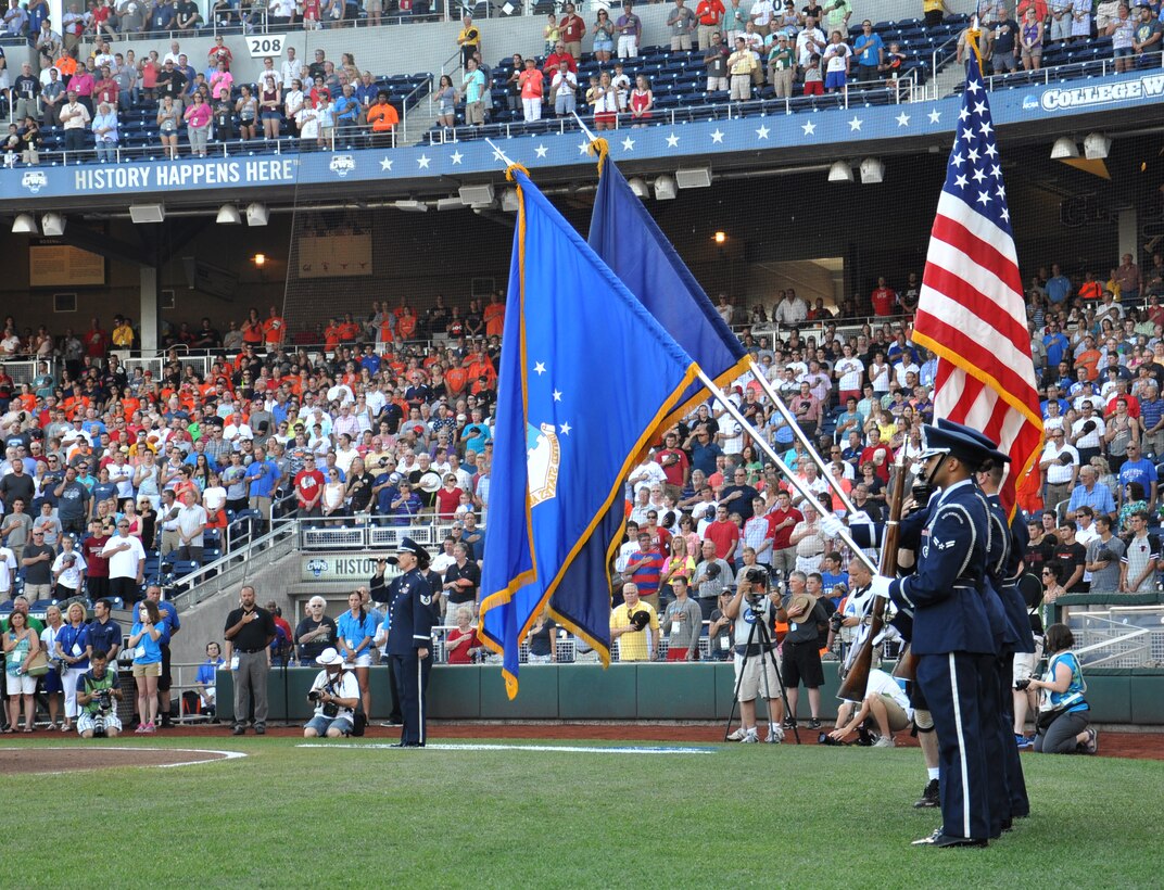 U.S. Air Force Tech. Sgt. Amanda Packard, U.S. Air Force Heartland of American Band, sings the national anthem as the Offutt Honor Guard presents the colors before the start of game one of the College World Series national championship at TD Ameritrade Park in Omaha, Nebraska on Monday, June 22. The Vanderbilt Commodores defeated the Virginia Cavaliers in the game 5 - 0. (U.S. Air Force photo by Ryan Hansen/Released)