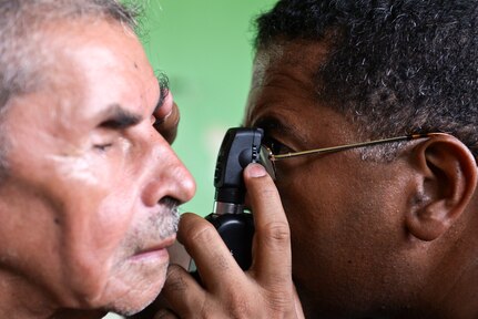 Dr. Miguel Coello, a Joint Task Force – Bravo Medical Element medical liaison officer, performs an eye exam on a patient during a medical readiness training exercise, June 2, 2015, at Corinto, Cortes, Honduras. Coello participates in 12-15 MEDRETEs each year in under-reached portions of Honduras and Central America. (U.S. Air Force photo by Staff Sgt. Jessica Condit)