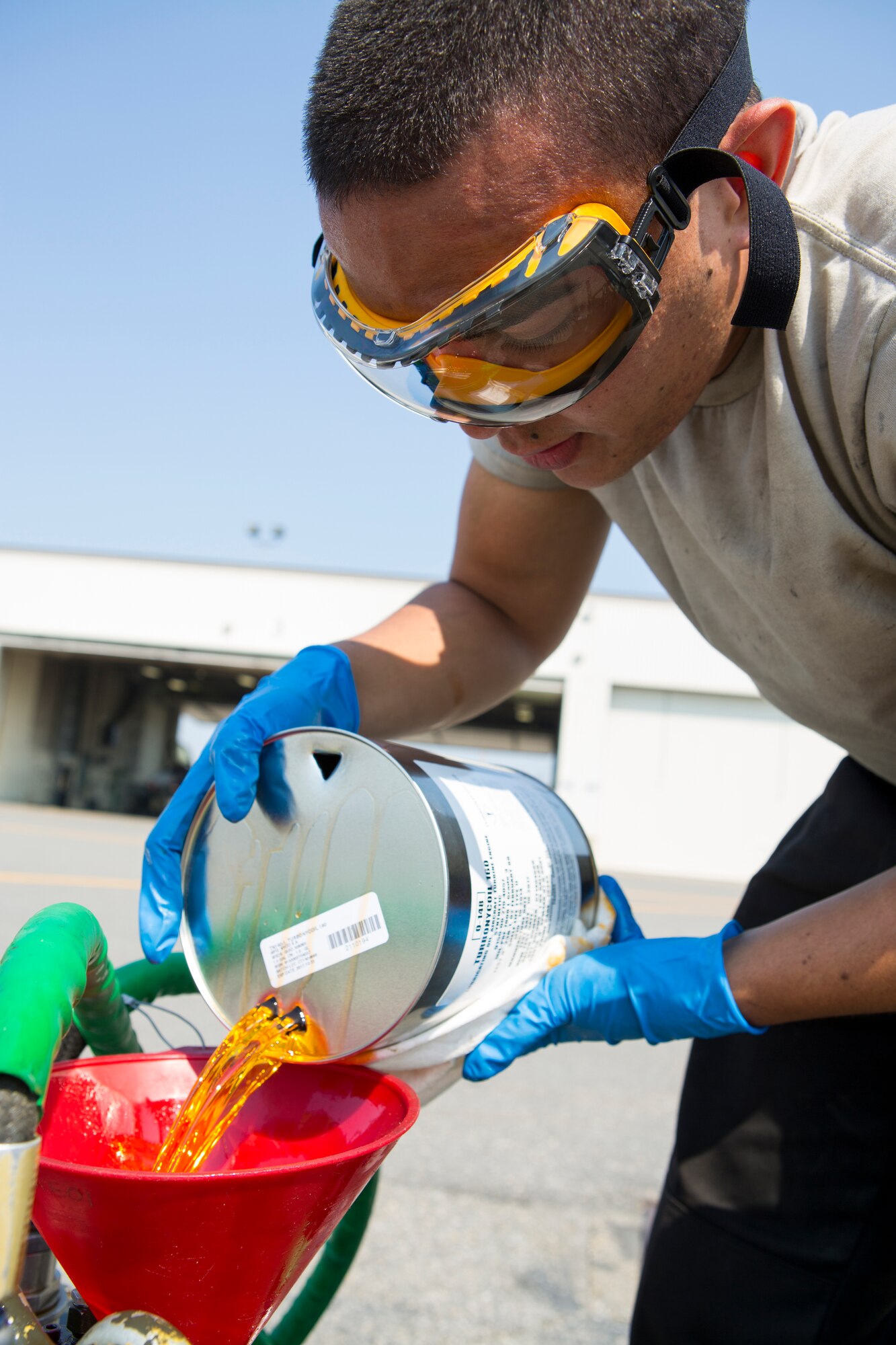 U.S. Air Force Senior Airman Edwin Rodriguez, a crew chief with the 18th Aggressor Squadron, pours oil into a canister during Exercise Northern Edge 15 at Eielson Air Force Base, Alaska, June 19, 2015. Northern Edge is Alaska’s premier joint training exercise designed to practice operations, techniques and procedures as well as enhance interoperability among the services. Thousands of service members from active duty, reserve and National Guard units are involved. (U.S. Marine Corps photo by Cpl. Suzanne Dickson/Released)