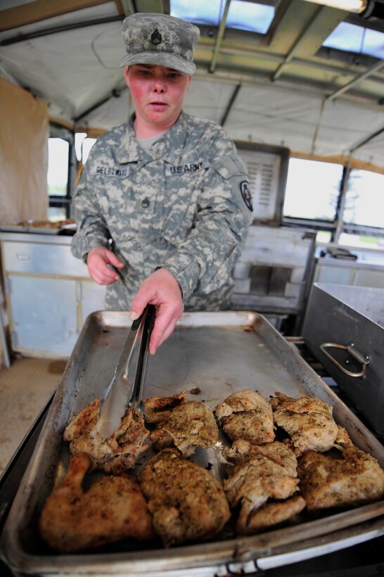 Illinois National Guard Army Staff Sgt. Libby Gelbowitz, 1344th Transportation Company food service specialist, prepares chicken for troops participating in Golden Coyote at Camp Lancer at Ellsworth Air Force Base, S.D., June 10, 2015. More than 500 troops were served each day during the 31st annual Golden Coyote exercise. (U.S. Air Force Photo by Airman 1st Class James L. Miller/Released)
