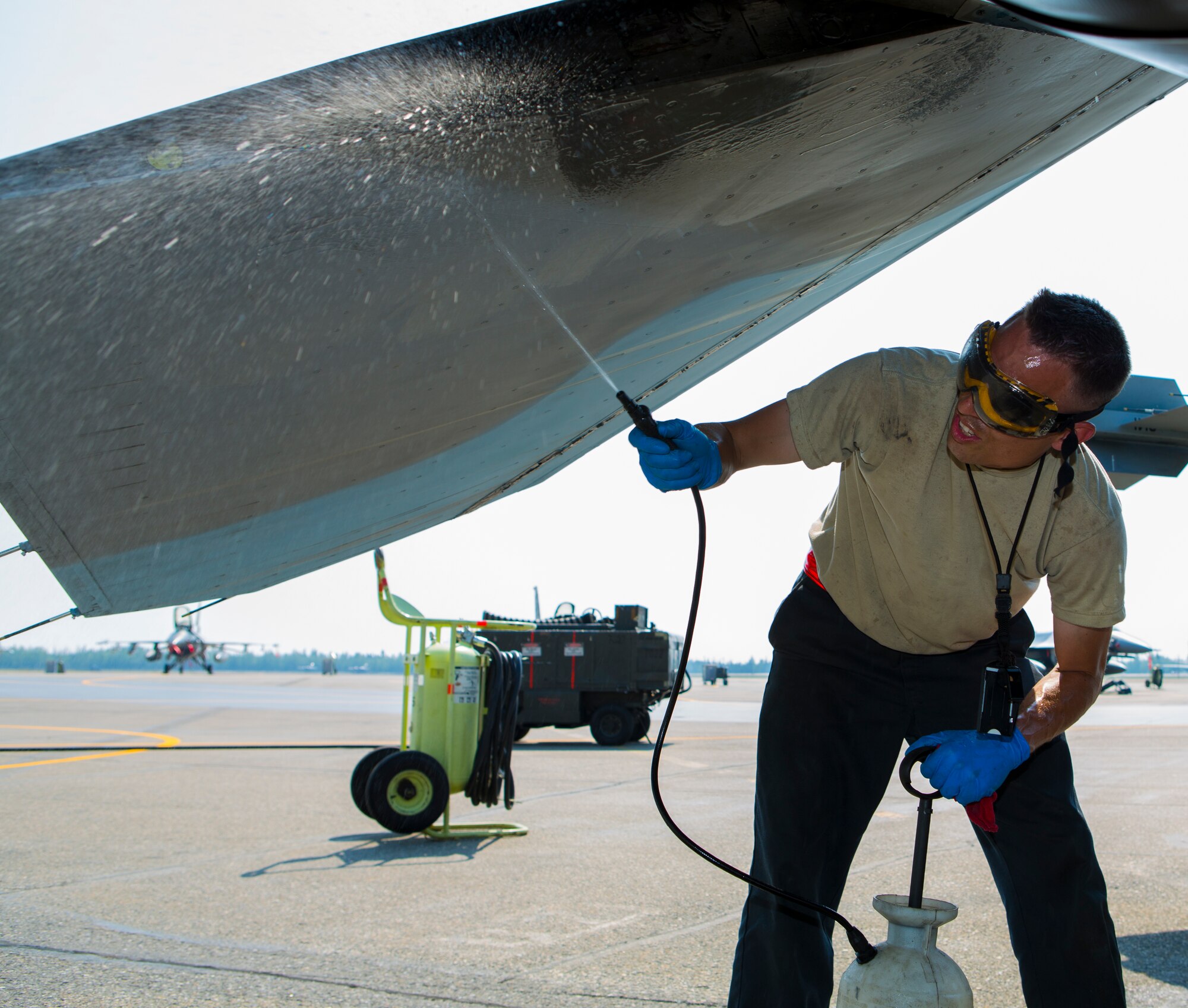 U.S. Air Force Staff Sgt. Eric L. Sandberg, a crew chief with the 18th Aggressor Squadron, rinses off a F-16C Fighting Falcon aircraft with water during Exercise Northern Edge 15 at Eielson Air Force Base, Alaska, June 19, 2015. Northern Edge is Alaska’s premier joint training exercise designed to practice operations, techniques and procedures as well as enhance interoperability among the services. Thousands of service members from active duty, reserve and National Guard units are involved. (U.S. Marine Corps photo by MCIPAC Combat Camera, Cpl. Suzanne Dickson/Released)