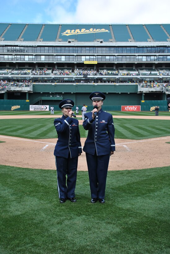 U.S. Air Force Airman First Class Michelle Doolittle and Stephanie Allen sing "God Bless America," at the 7th inning stretch of the Oakland A's baseball game. They performed as a part of the team's memorial day game. (Oakland A's photo/Released) 