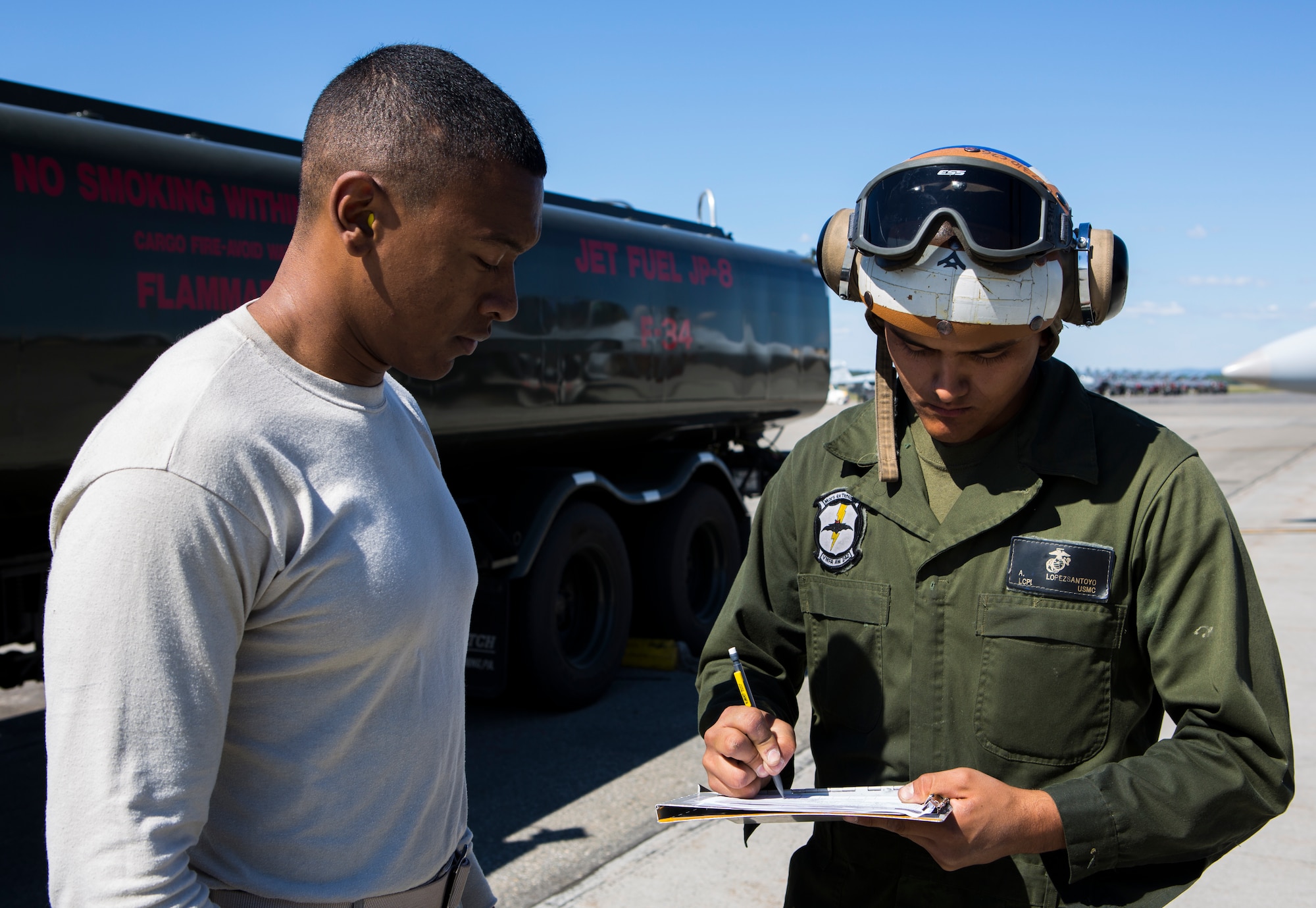 U.S. Marine Corps Lance Cpl. Alberto Lopezsantoyo, right, Marine All-Weather Fighter Attack Squadron 242, 1st Marine Aircraft Wing, power liner, signs a fuel receipt from U.S. Air Force Airman 1st Class Anthony Jackson, 18th Logistics Readiness Squadron, fuel distribution operator, during Exercise Northern Edge 15 at Eielson Air Force Base, Alaska, June 18, 2015. Northern Edge is Alaska’s premier joint training exercise designed to practice operations, techniques and procedures as well as enhance interoperability among the services. Thousands of Airmen, Soldiers, Sailors, Marines and Coast Guardsmen from active duty, Reserve and National Guard units are involved. (U.S. Marine Corps photo by Cpl. Suzanne Dickson/Released)