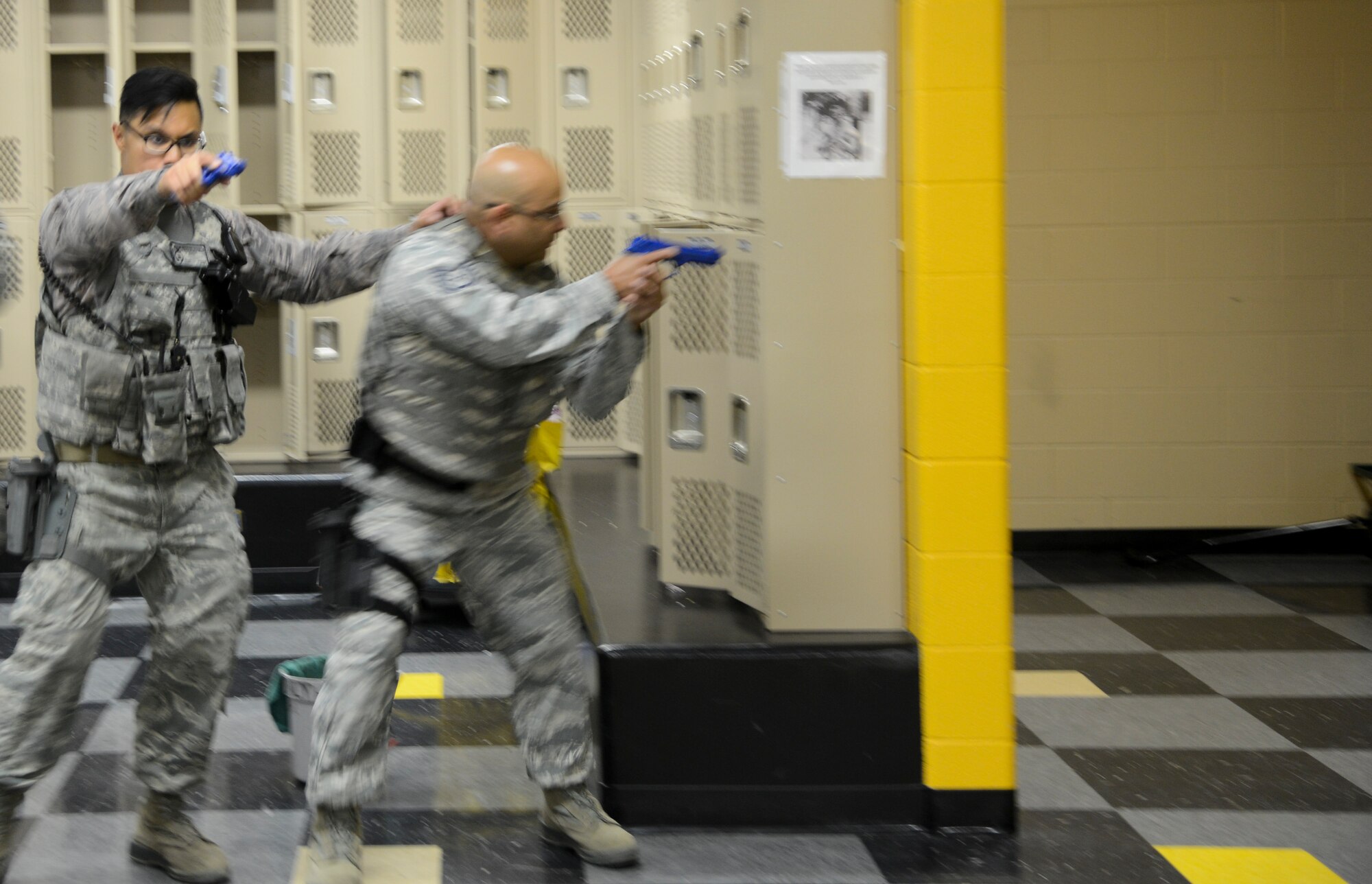 PETERSON AIR FORCE BASE, Colo. - Staff Sgt. Kevin Delpuerto (left), 721st Security Forces Squadron and Tech. Sgt. Adislado Garcia, 302nd Security Forces Squadron, search for an active shooter during a training exercise scenario at the Fort Carson middle school June 18, 2015. Several security forces Airmen from Cheyenne Mountain Air Force Station and Peterson Air Force Base participated in the training. (U.S. Air Force photo by Tech. Sgt. Jared Marquis)