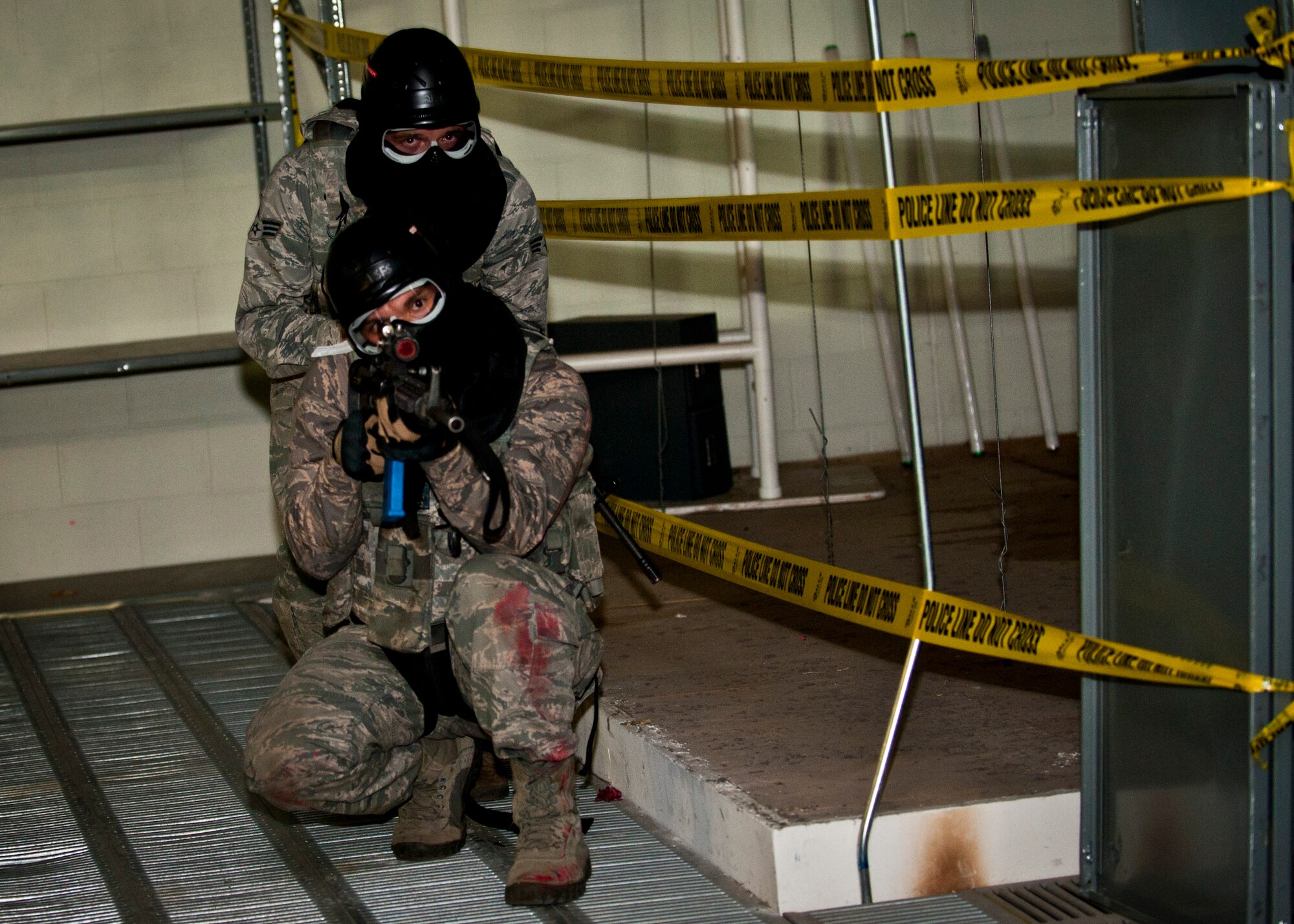 PETERSON AIR FORCE BASE, Colo. – Two Airmen from the 721st Security Forces Squadron clear an area of the industrial area of a warehouse to find two rogue Airmen with weapons in a scenario during an annual training mission at the 21st Security Forces Training Complex, June 16. 721st SFS members conducted an active shooter, live-fire training using non-lethal training ammunition, which allows for the most realistic force-on-force training. (U.S. Air Force photo by Airman 1st Class Rose Gudex)