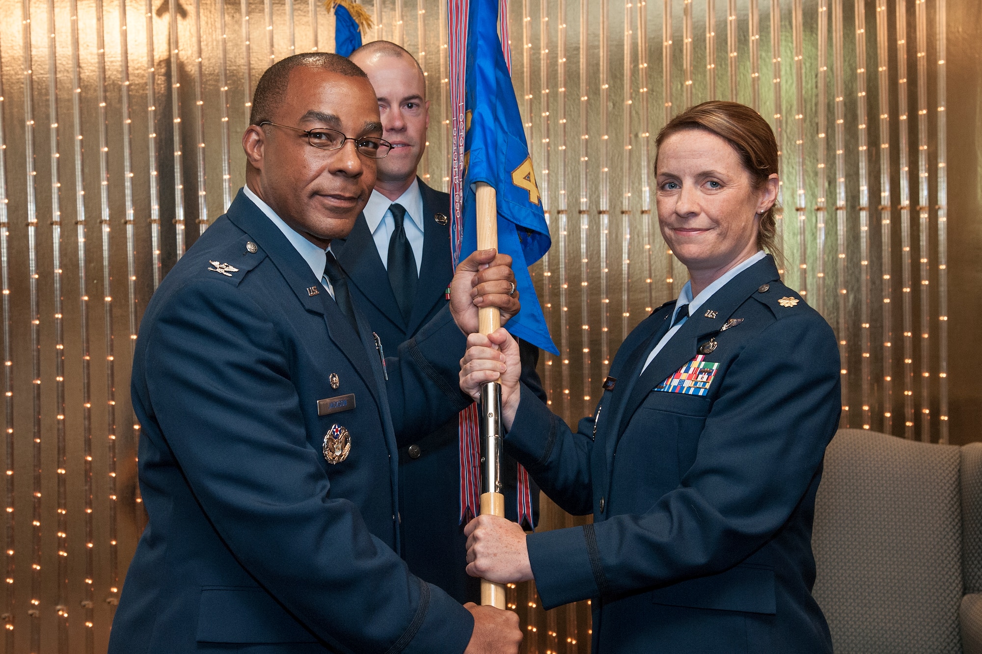 PETERSON AIR FORCE BASE, Colo. - Maj. Meghan M. Szwarc, accepts the 4th Manpower Requirements Squadron Flag from Col. Robert S. Jackson Jr, commander, Air Force Manpower Analysis Agency, as she assumes command of the squadron June 19, 2015.  The assumption of command ceremony was held at The Club Lounge on Peterson Air Force Base. (U.S. Air Force photo by Craig Denton)