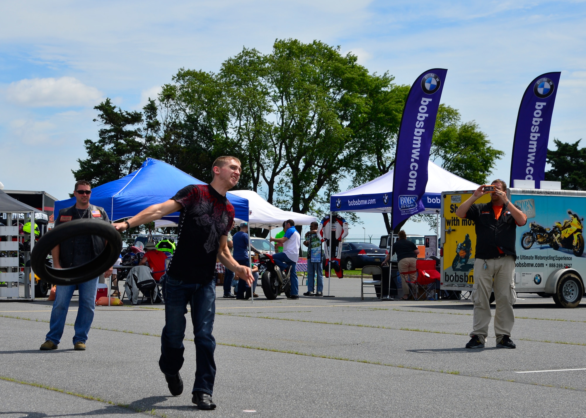 Staff Sgt. Mykael Charlton, 436th Maintenance Squadron aircraft structural maintenance craftsman, throws a motorcycle tire during a tire toss competition at Motorcycle Safety Day June 19, 2015, at Dover Air Force Base, Del. Other events included beer goggle tricycle races, slow drag competition, demonstration rides and lessons on how to perform pre-ride inspections. (U.S. Air Force photo/Airman 1st Class William Johnson)
