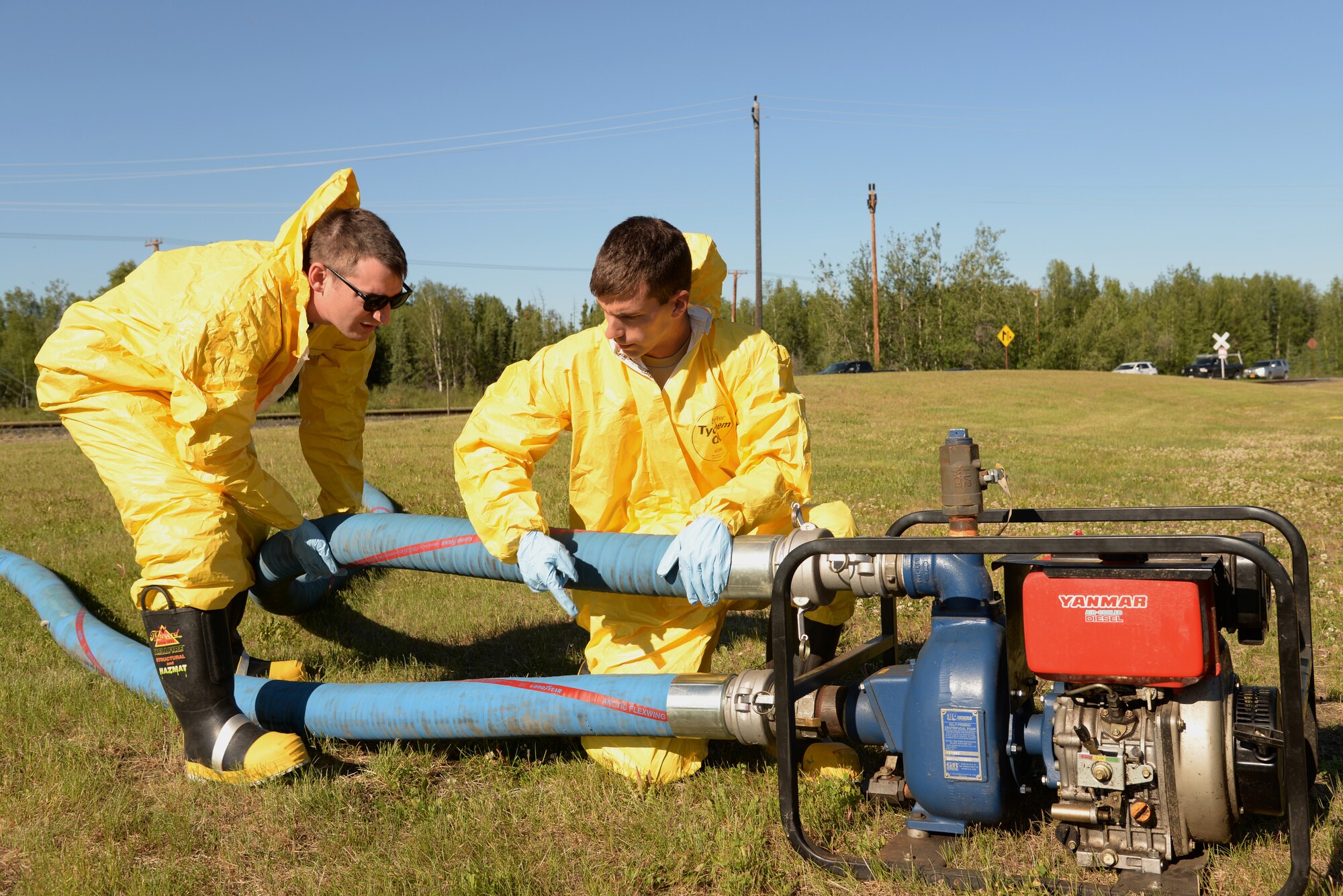 U.S. Air Force Airmen 1st Class Alexander Hartman and Patrick Chittenden, 354th Civil Engineer Squadron water and fuels system maintenance technicians, secure hoses to a generator designed to vacuum up liquid waste that has pooled on the ground during a simulated 4.2-million gallon fuel spill exercise June 17, 2015, at Eielson Air Force Base, Alaska. The exercise is a Federal requirement conducted tri-annually to train and prepare fuels management and emergency services personnel in minimizing the environmental impact of a spill and in protecting and preserving public health and safety. (U.S. Air Force photo by Staff Sgt. Kirsten Wicker/Released)