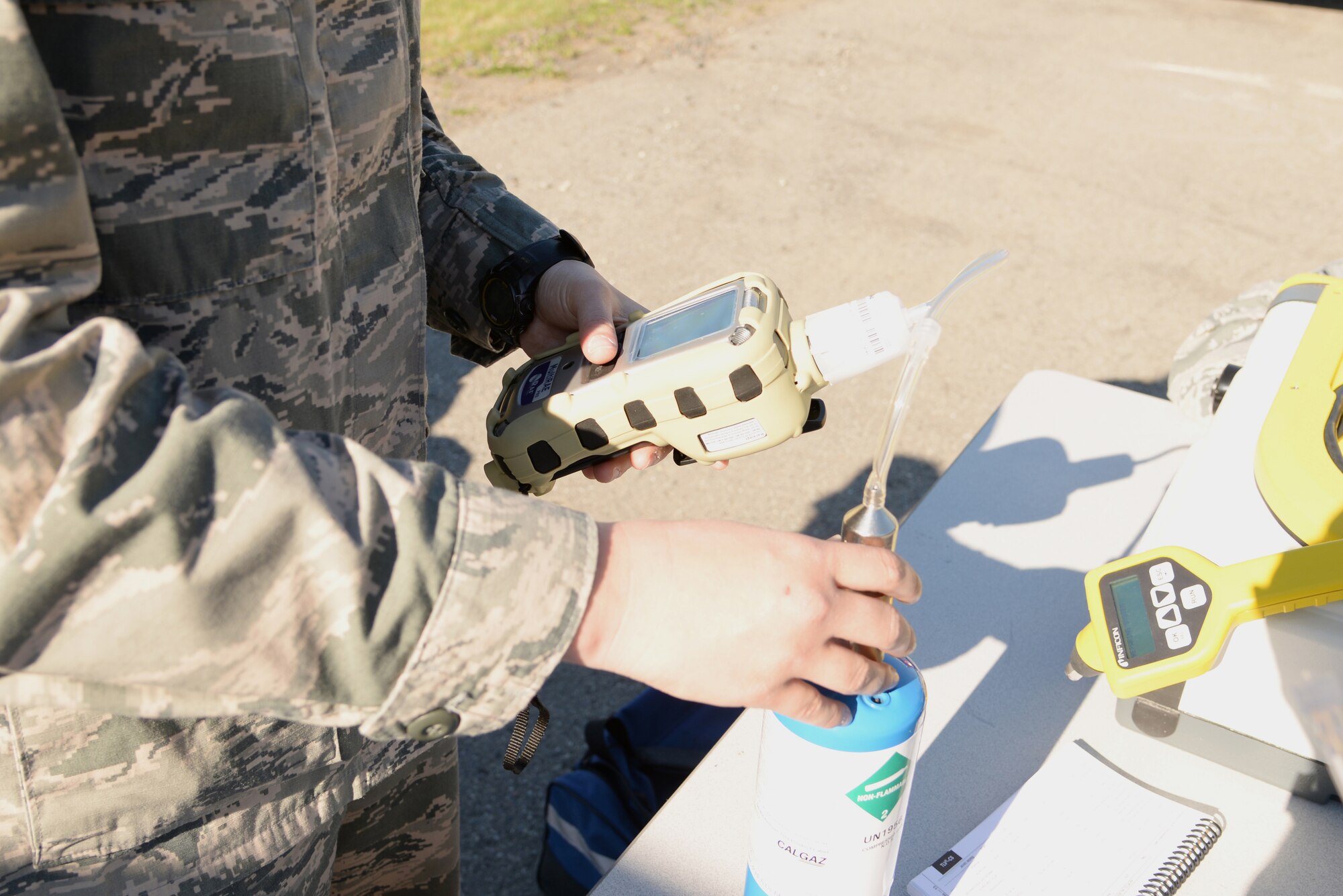 U.S. Air Force Senior Airman Alexandria Stufflebeam, a 354th Medical Operations Squadron bioenvironmental engineering technician, calibrates equipment that will test the air for toxins during a simulated 4.2-million gallon fuel spill exercise June 17, 2015, at Eielson Air Force Base, Alaska. The exercise is a Federal requirement conducted tri-annually to train and prepare fuels management and emergency services personnel in minimizing the environmental impact of a spill and in protecting and preserving public health and safety. (U.S. Air Force photo by Staff Sgt. Kirsten Wicker/Released)
